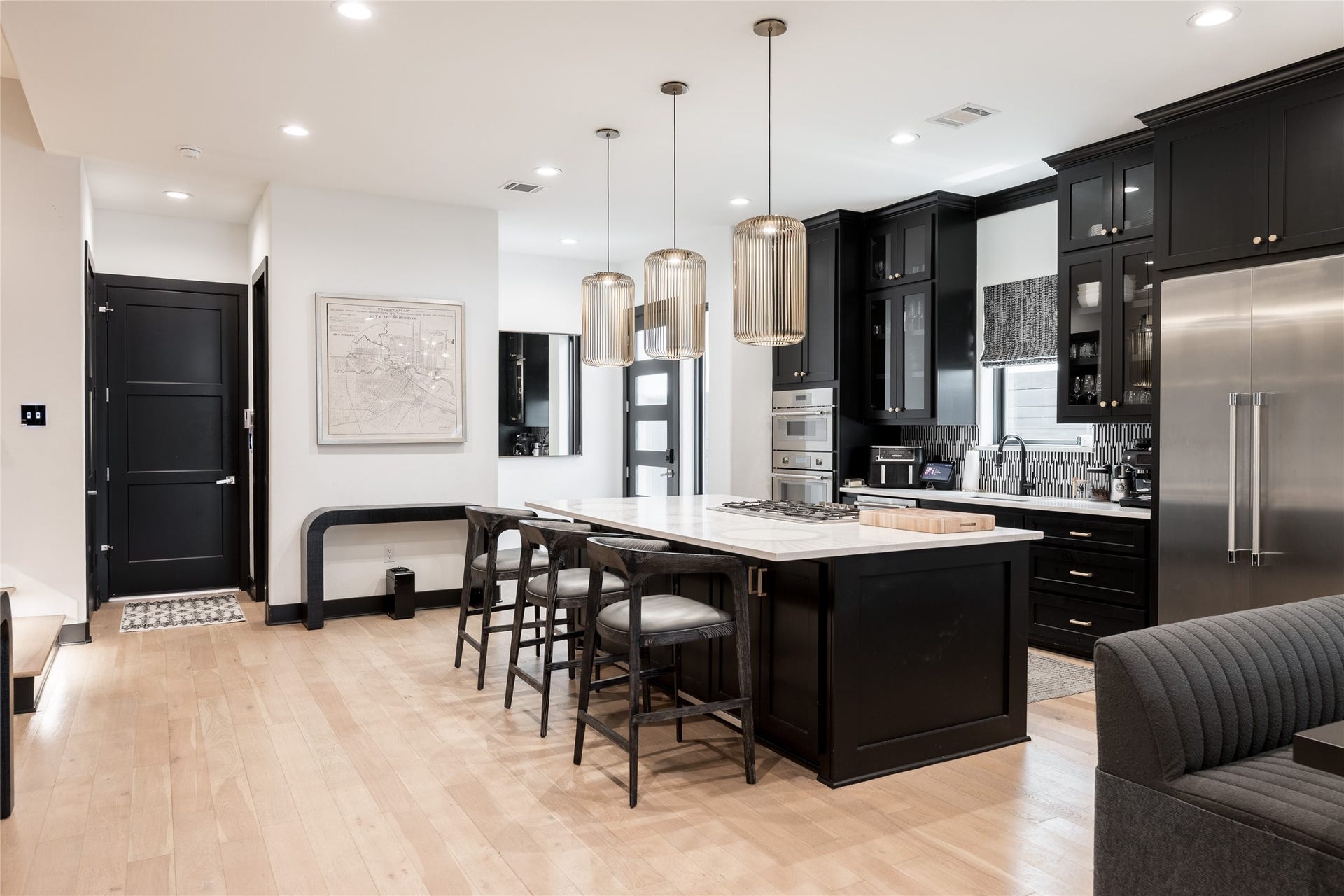 906 Knox Street, Houston, TX 77007 A spacious center island anchors the completely renovated kitchen, pairing substantial counter space with custom cabinetry, stainless steel appliances and striking designer lighting.