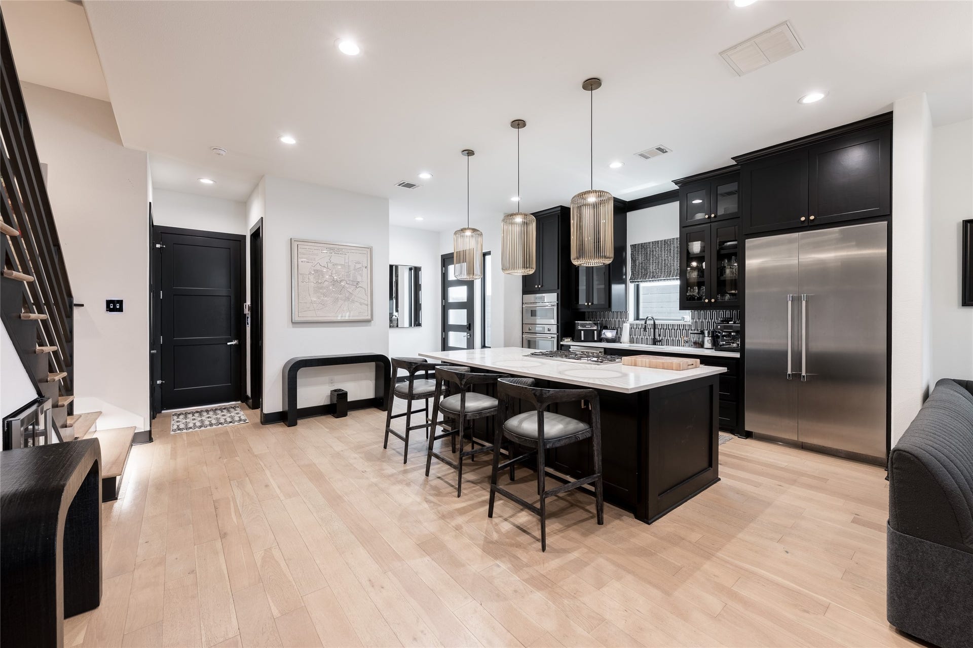 906 Knox Street, Houston, TX 77007 The completely renovated kitchen makes a striking statement with sleek black cabinetry, expansive countertops, statement lighting and a generous island designed for both everyday living and entertaining.