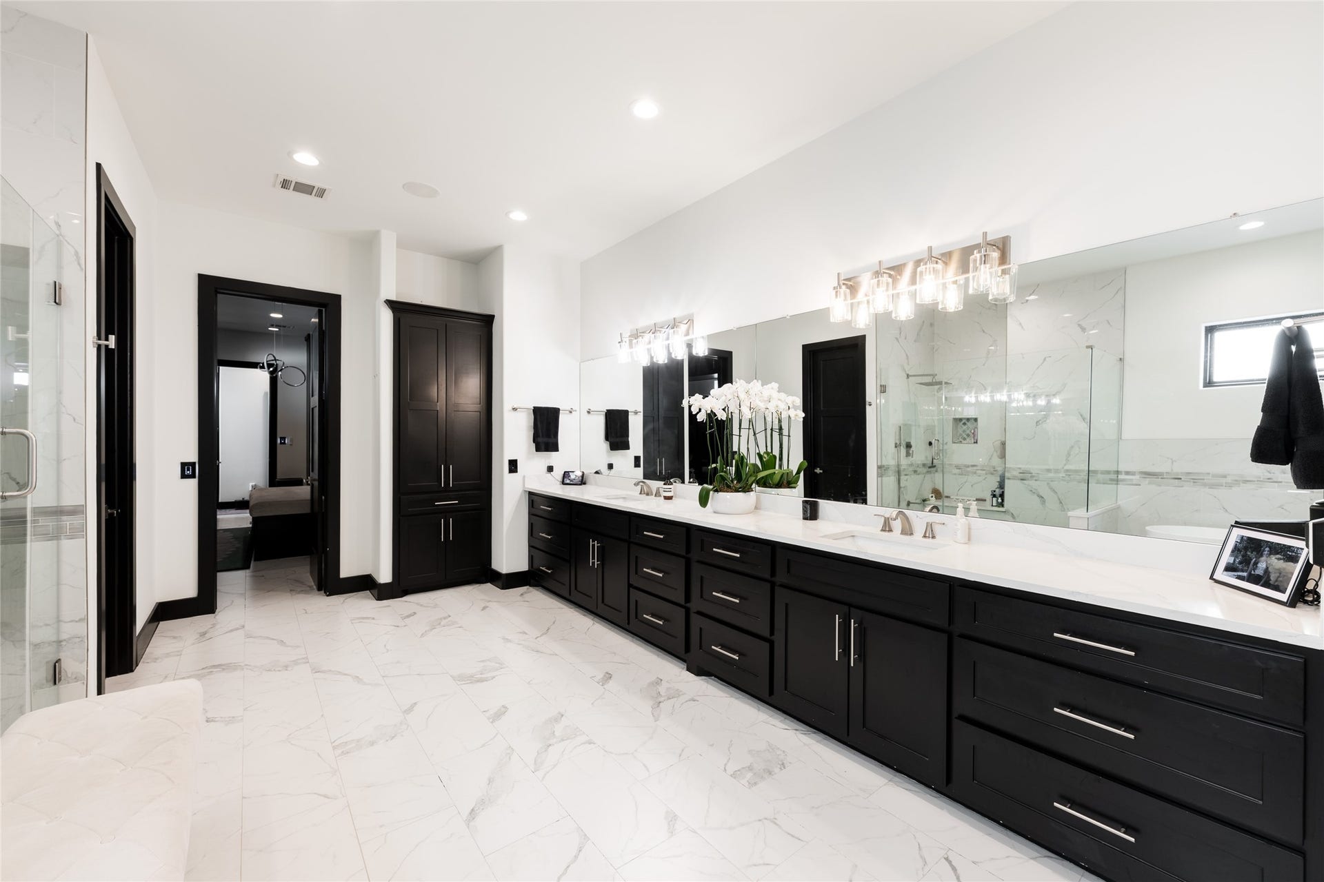 906 Knox Street, Houston, TX 77007 Thoughtful storage is integrated throughout the primary bath, with a substantial dual vanity, floor-to-ceiling linen cabinetry, and generous counter space for everyday functionality.