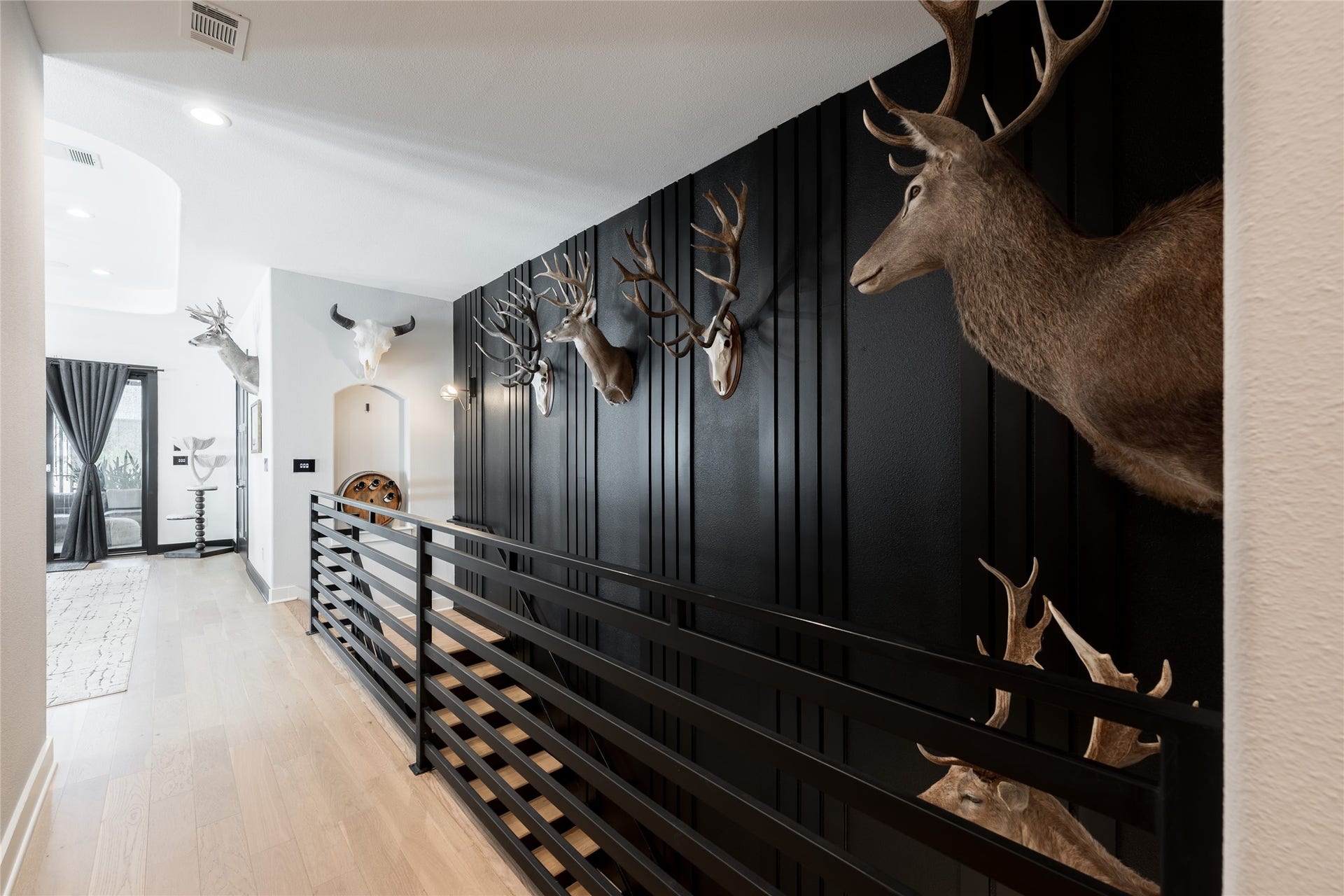 906 Knox Street, Houston, TX 77007 A gallery-like walkway creates a memorable transition to the homes next entertaining space, pairing warm floors with bold architectural detailing.