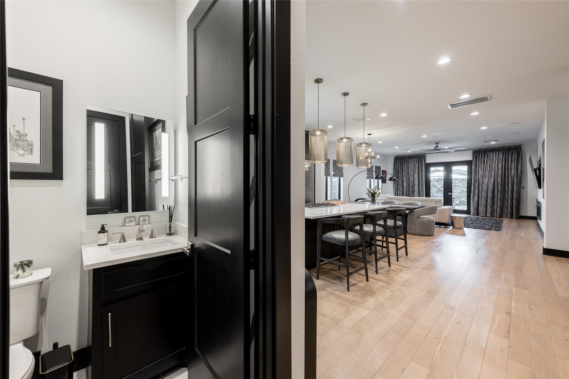 906 Knox Street, Houston, TX 77007 Conveniently positioned off the main living space, the powder bath features sleek black cabinetry, crisp countertops and contemporary finishes that echo the homes overall design.
