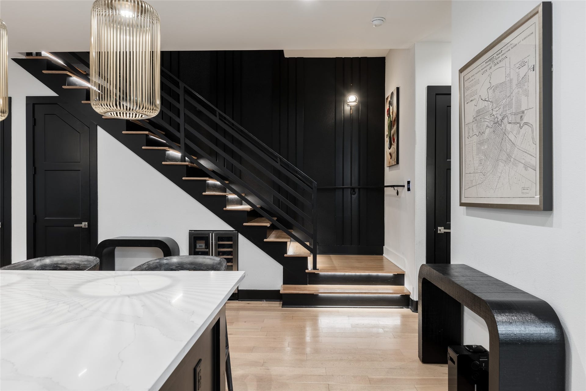 906 Knox Street, Houston, TX 77007 The illuminated staircase becomes an architectural focal point, pairing warm wood treads with bold black railings and a dramatic paneled accent wall.