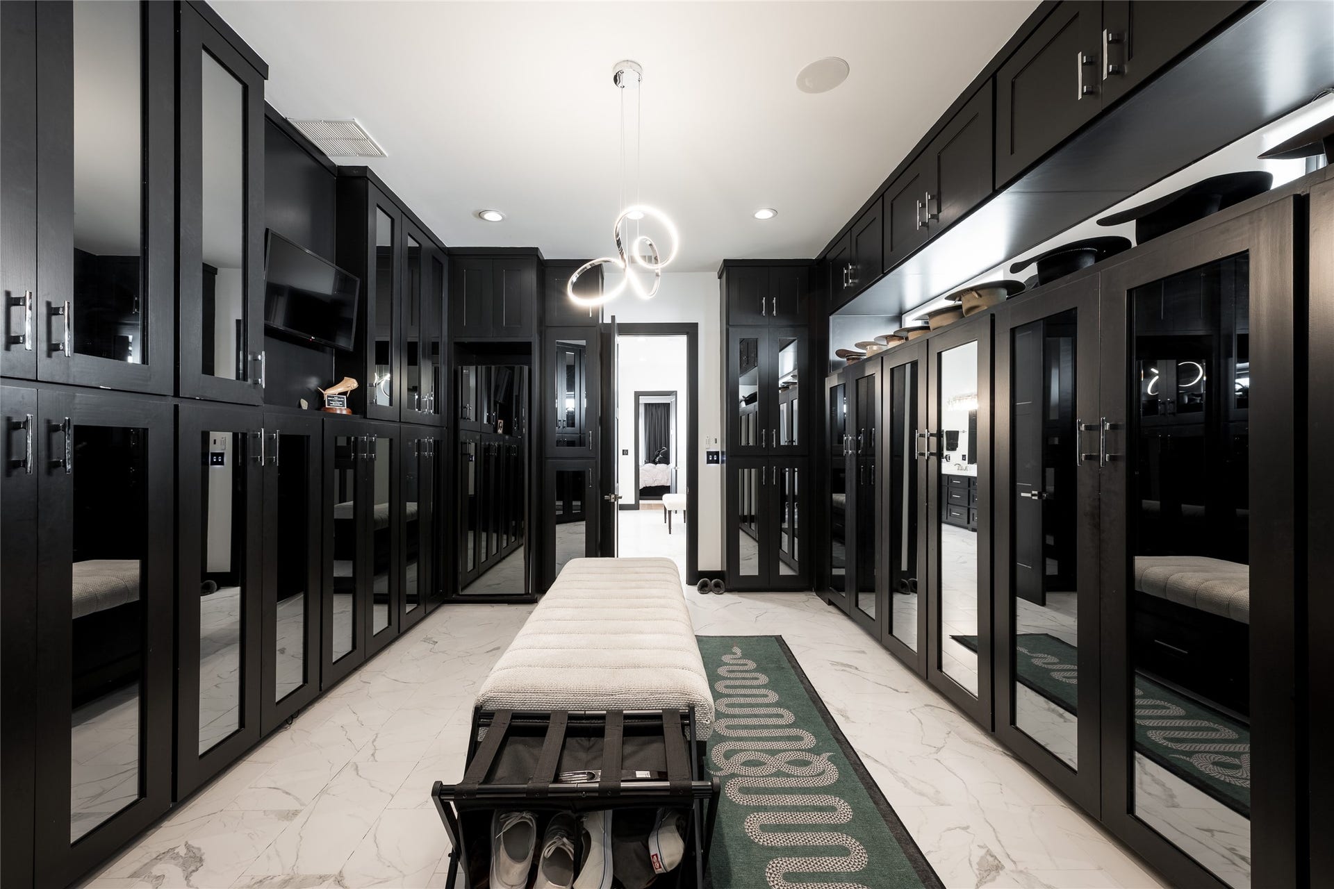 906 Knox Street, Houston, TX 77007 A boutique-inspired dressing room brings organization and presentation together, with tailored black cabinetry, integrated lighting, mirrored details, and abundant storage throughout.
