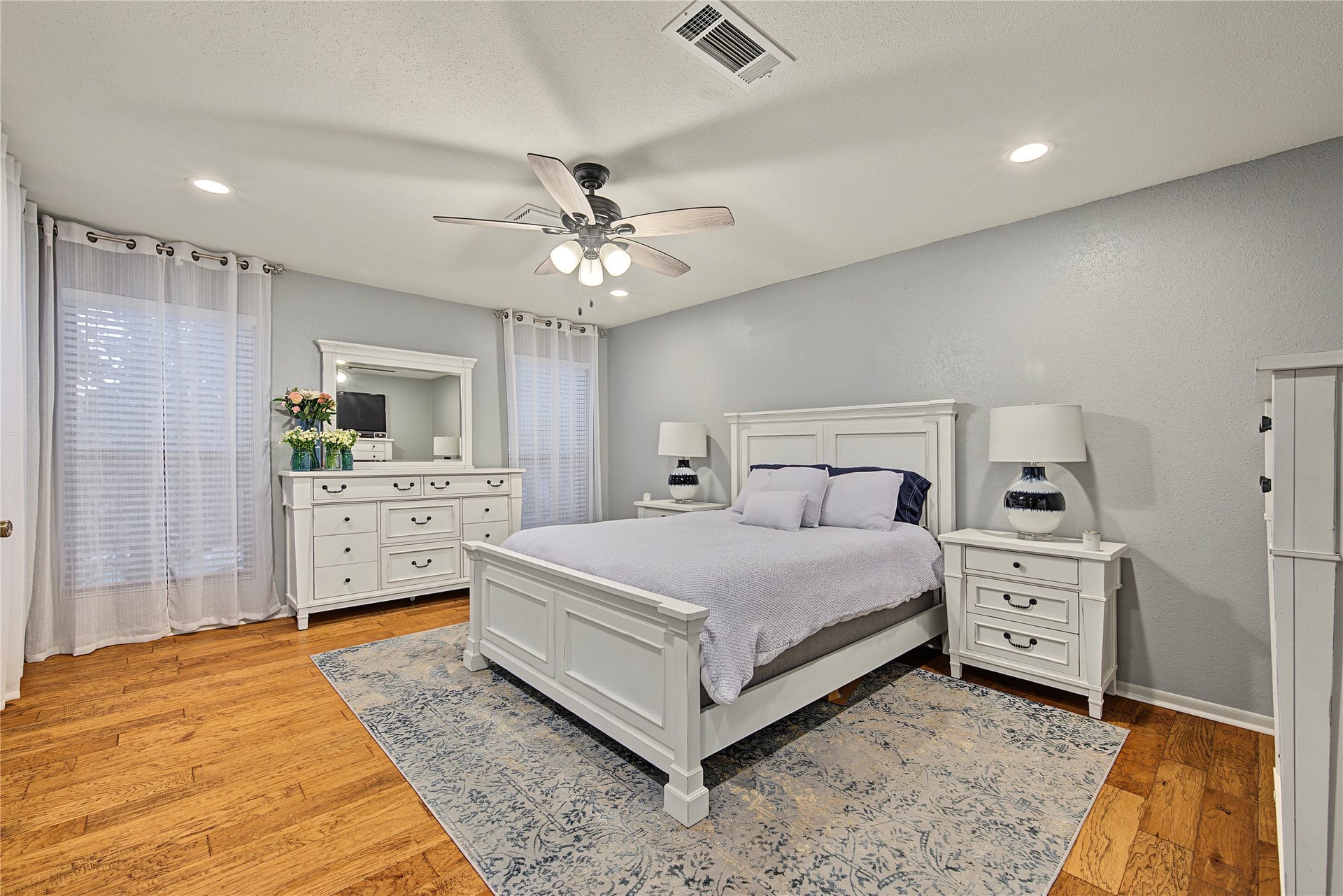 725 Worthshire Street, Houston, TX 77008 Spacious primary bedroom with wood look laminate flooring and ceiling fan