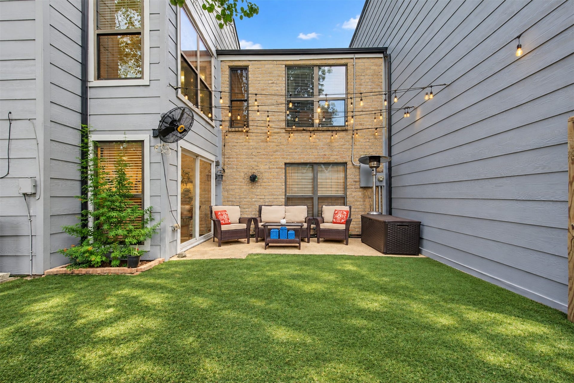 725 Worthshire Street, Houston, TX 77008 Private courtyard with patio seating and decorative string lighting.