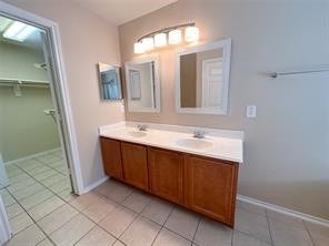 14420 Birch Knoll Lane, Houston, TX 77047 Primary bathroom has double vanity, bright lighting and mirros
