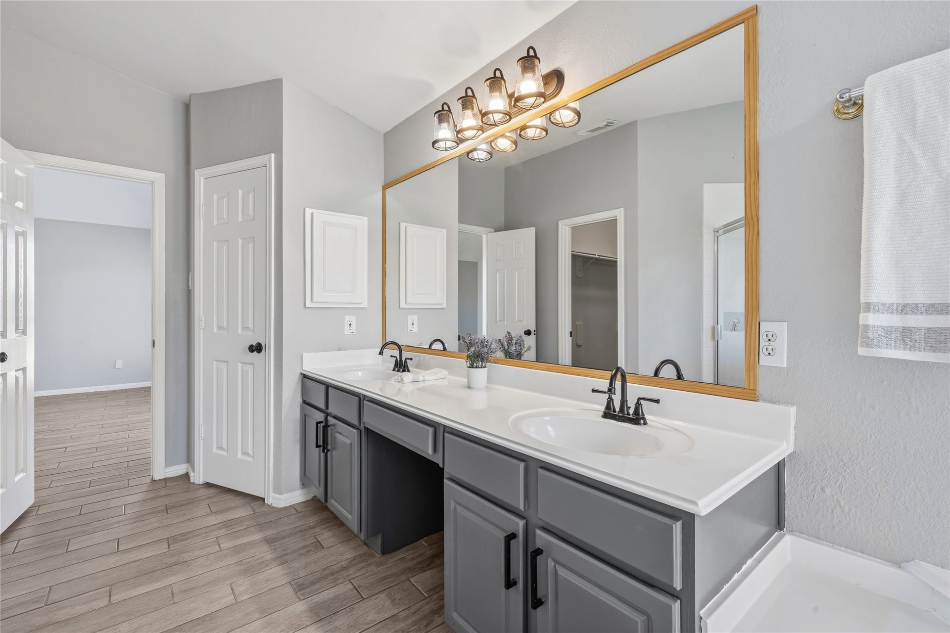4011 Grayson Court, Missouri City, TX 77459 Spacious bathroom featuring a dual-sink vanity with sleek black fixtures, a large mirror, and stylish lighting.