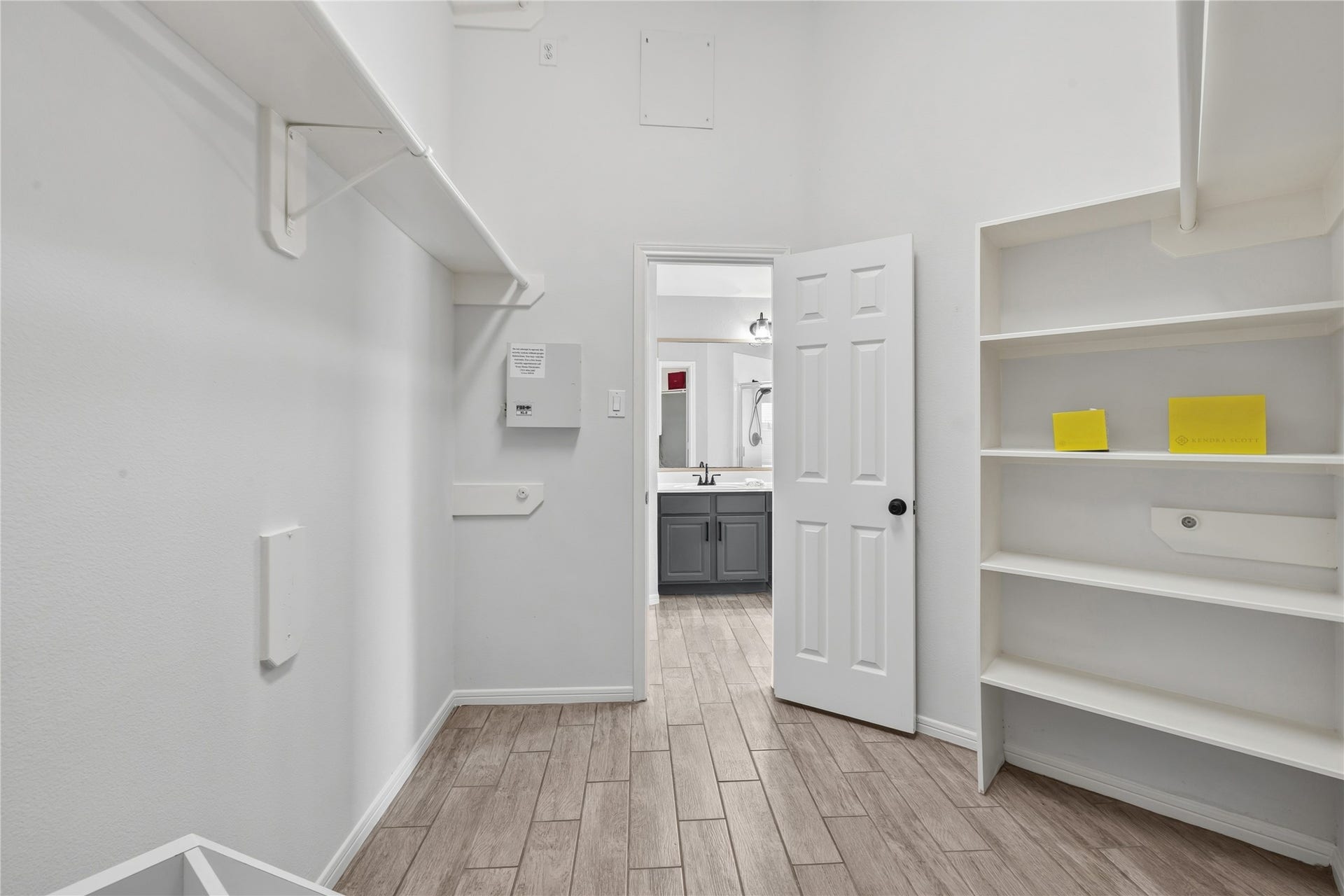 4011 Grayson Court, Missouri City, TX 77459 Spacious walk-in closet featuring built-in shelving and ample hanging space, leading to a bathroom with stylish blue cabinetry.