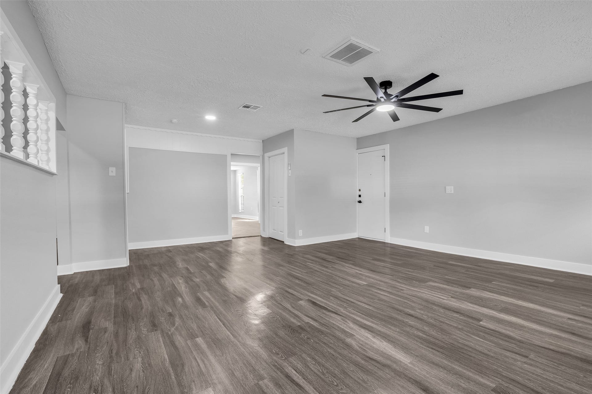 A second, oversized living space with a ceiling fan and recessed lighting, ready for game nights, a media setup or a home gym.