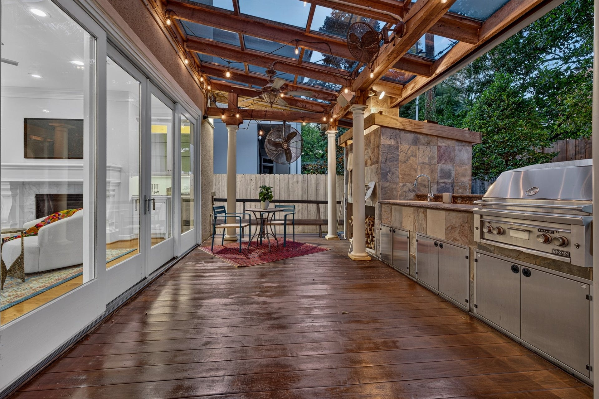 4420 Darsey Street, Bellaire, TX 77401 The glass covered outdoor kitchen combines stone finishes, stainless steel cooking equipment and exposed wood beams.