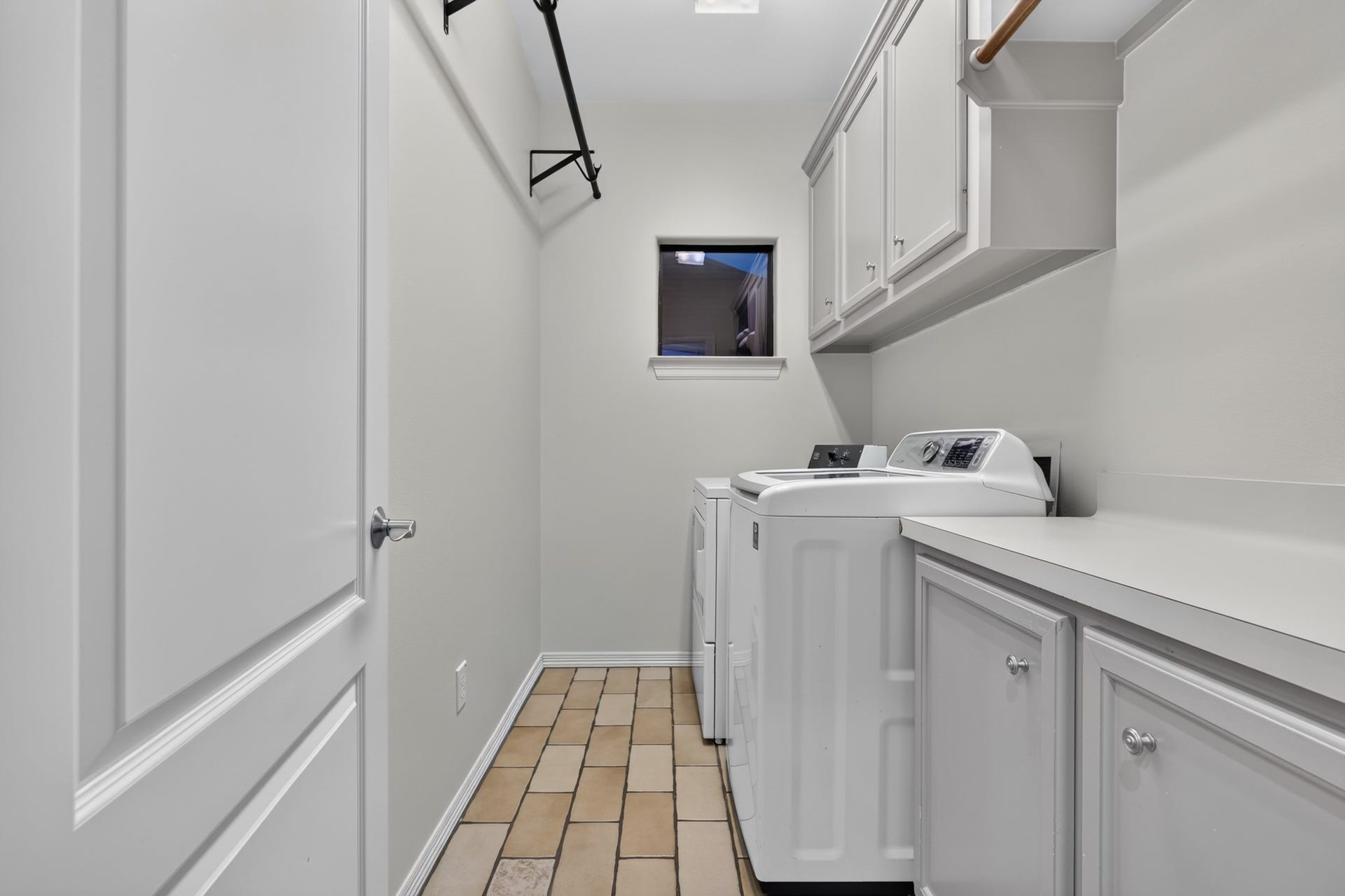 4420 Darsey Street, Bellaire, TX 77401 The laundry room offers built-in cabinetry and a work surface, with additional storage above the washer and dryer.
