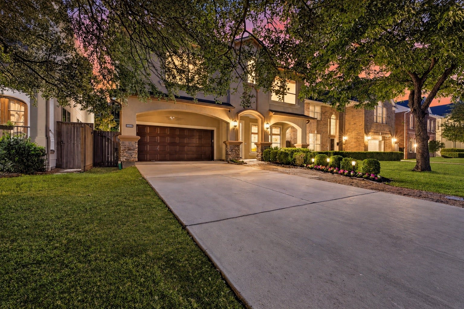 4420 Darsey Street, Bellaire, TX 77401 The wide driveway provides additional parking, with mature trees and landscaped beds framing the home's entrance.