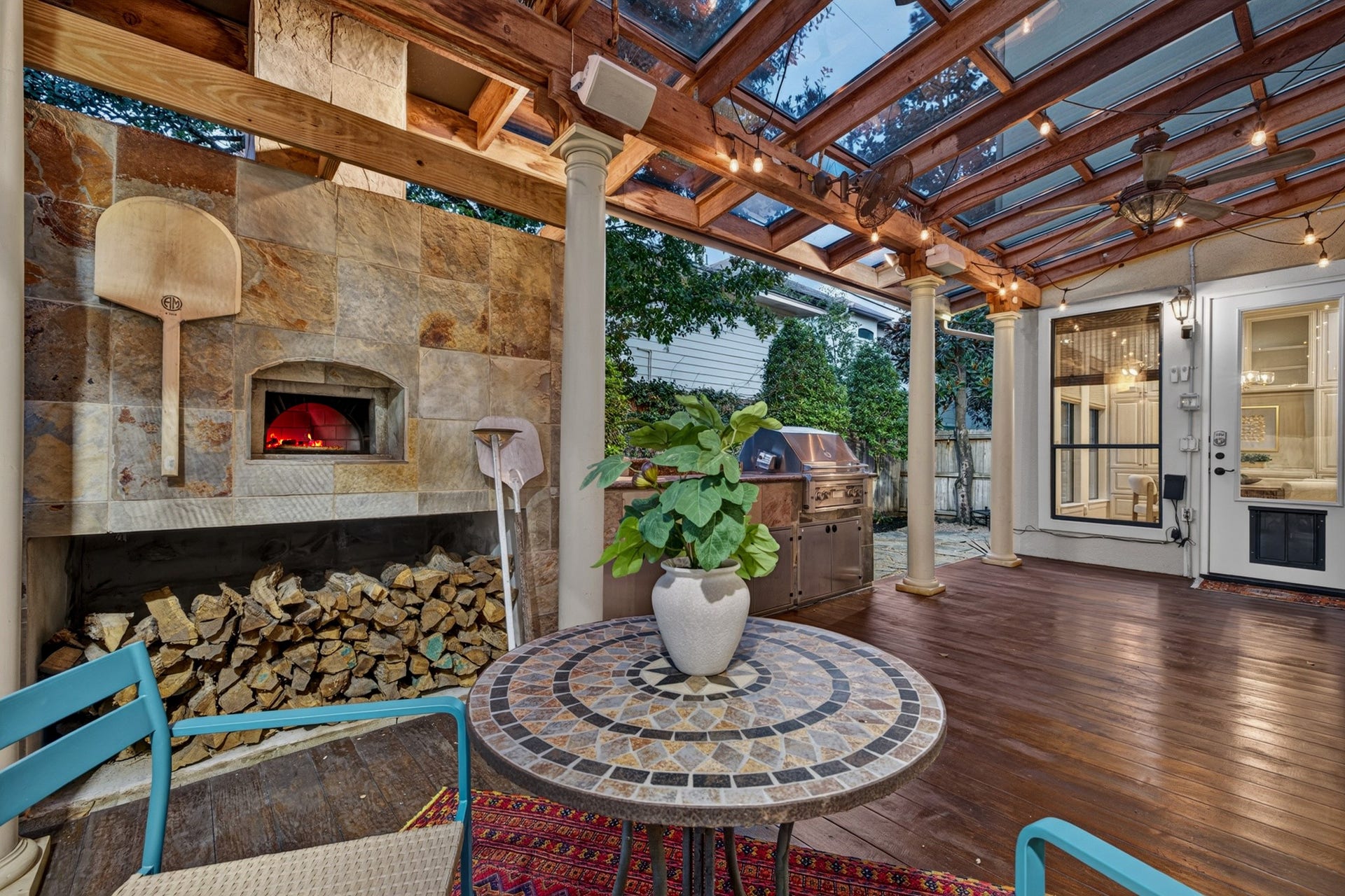 4420 Darsey Street, Bellaire, TX 77401 The covered patio extends the living space outdoors, with with an Italian pizza oven and room to dine and relax beneath exposed wood beams.