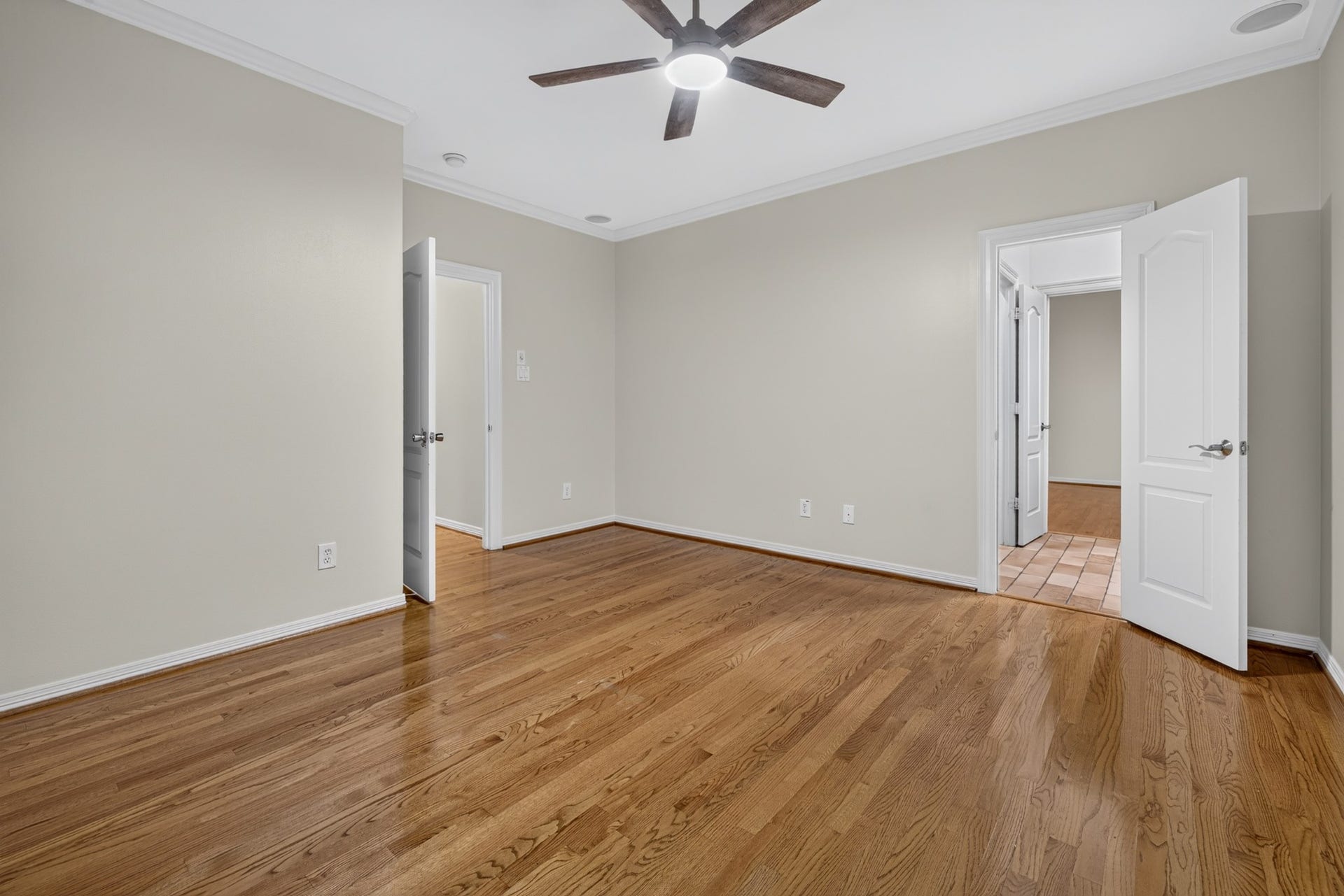 4420 Darsey Street, Bellaire, TX 77401 A secondary bedroom features wood flooring, neutral walls and a ceiling fan, ready for your personal style.