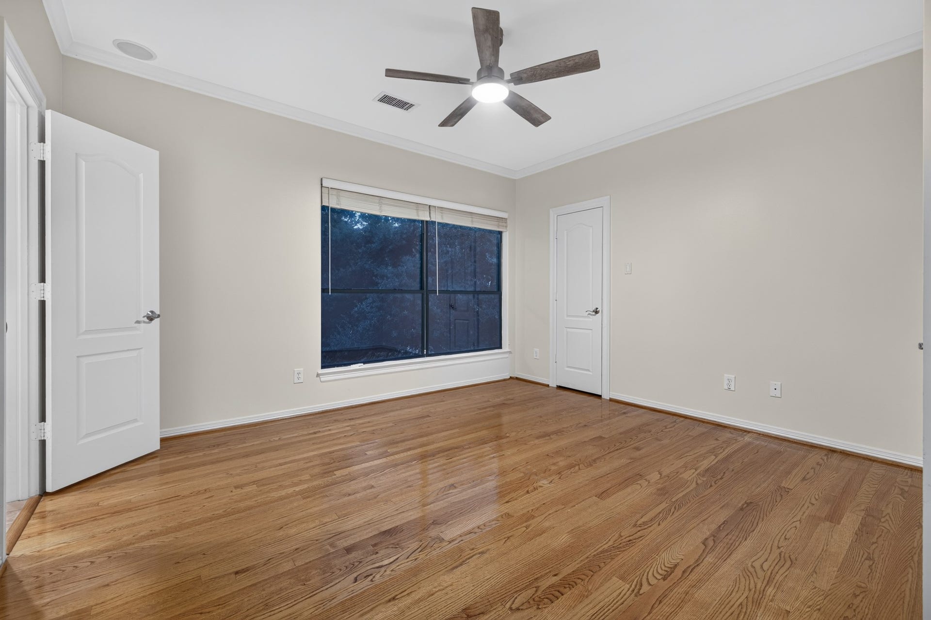4420 Darsey Street, Bellaire, TX 77401 Wood flooring and a ceiling fan complement this secondary bedroom's simple, versatile layout.