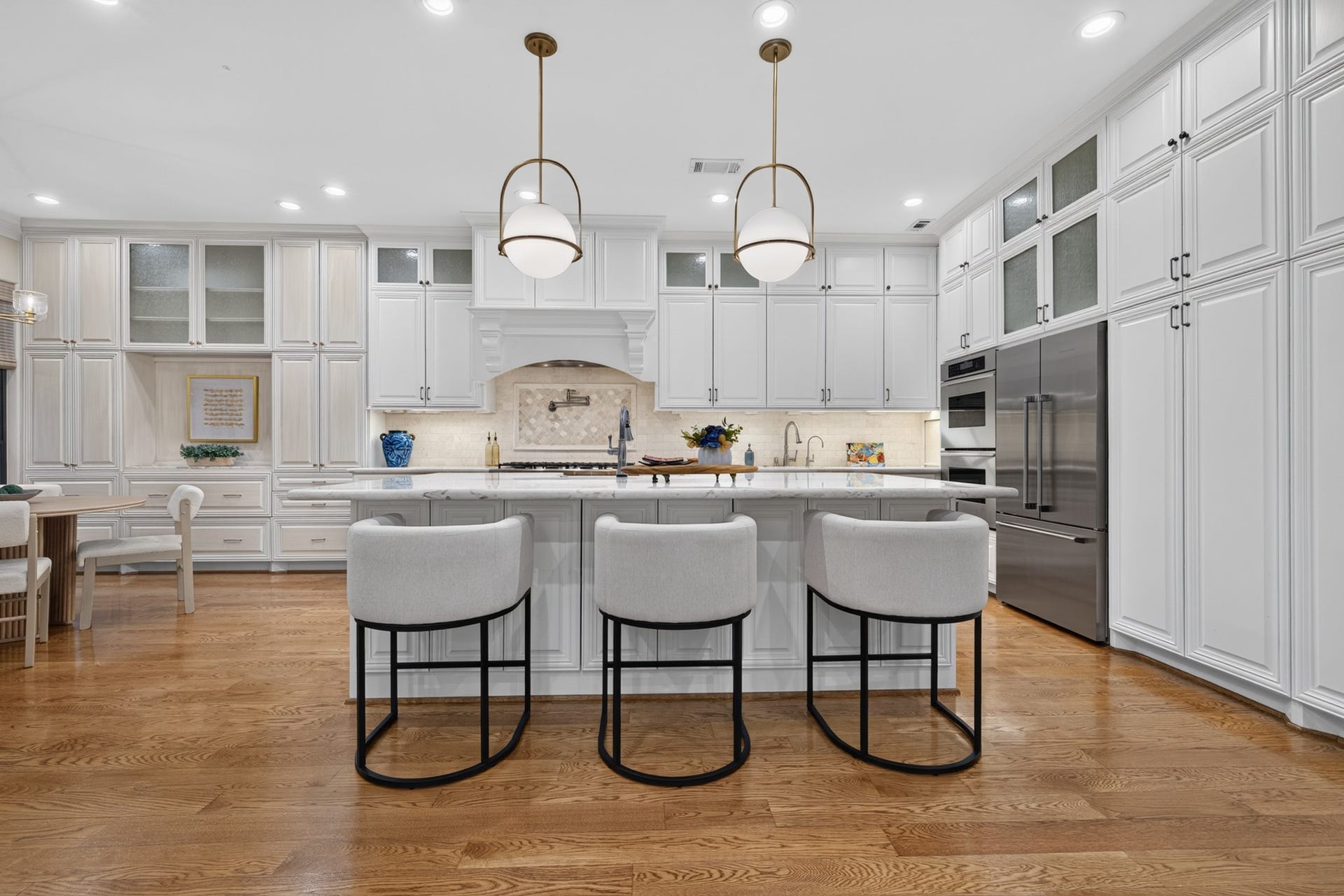 4420 Darsey Street, Bellaire, TX 77401 A generous island with seating anchors the kitchen, complemented by white cabinetry and updated pendant lighting.