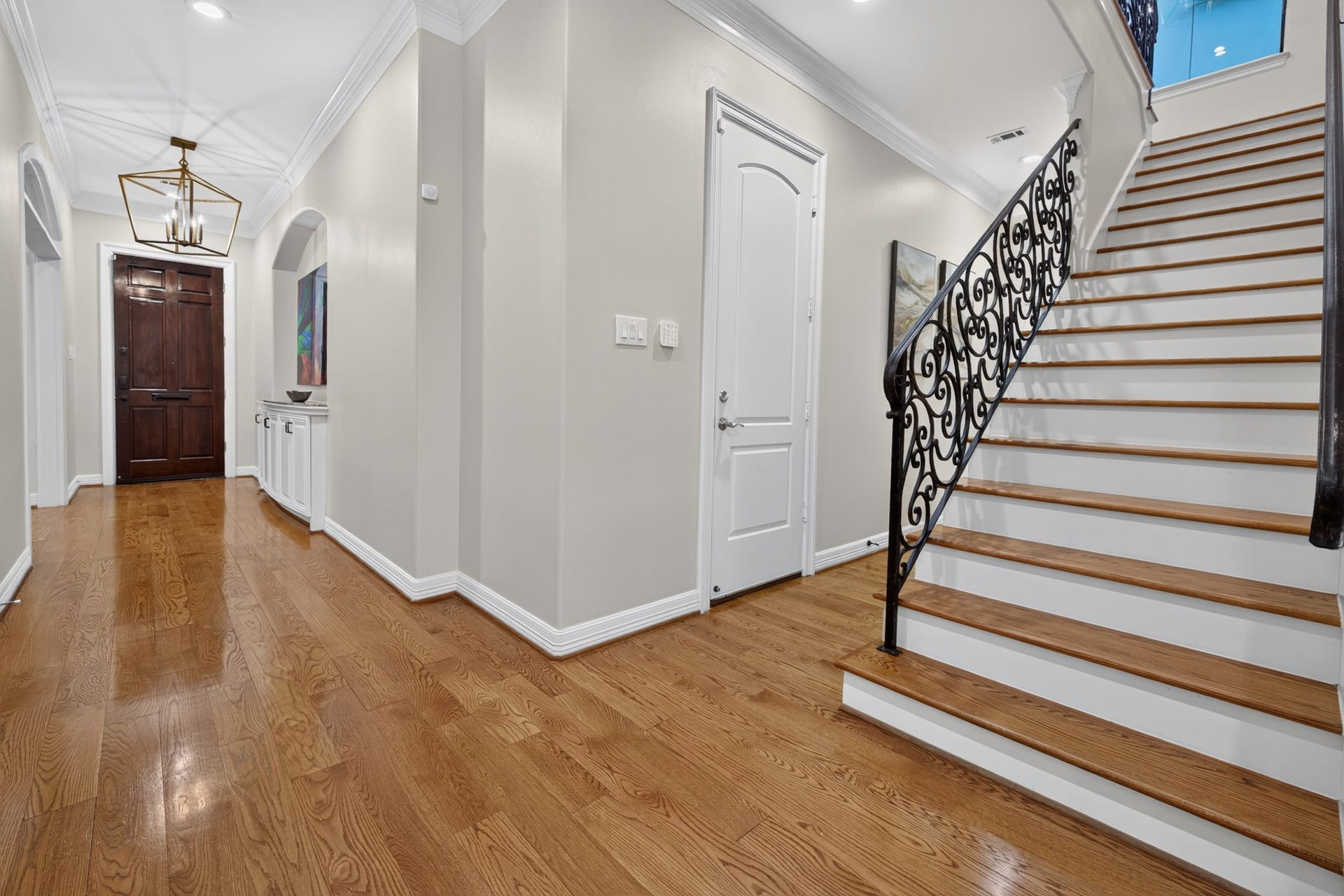 4420 Darsey Street, Bellaire, TX 77401 A welcoming foyer features wood flooring and a staircase with decorative iron railing.