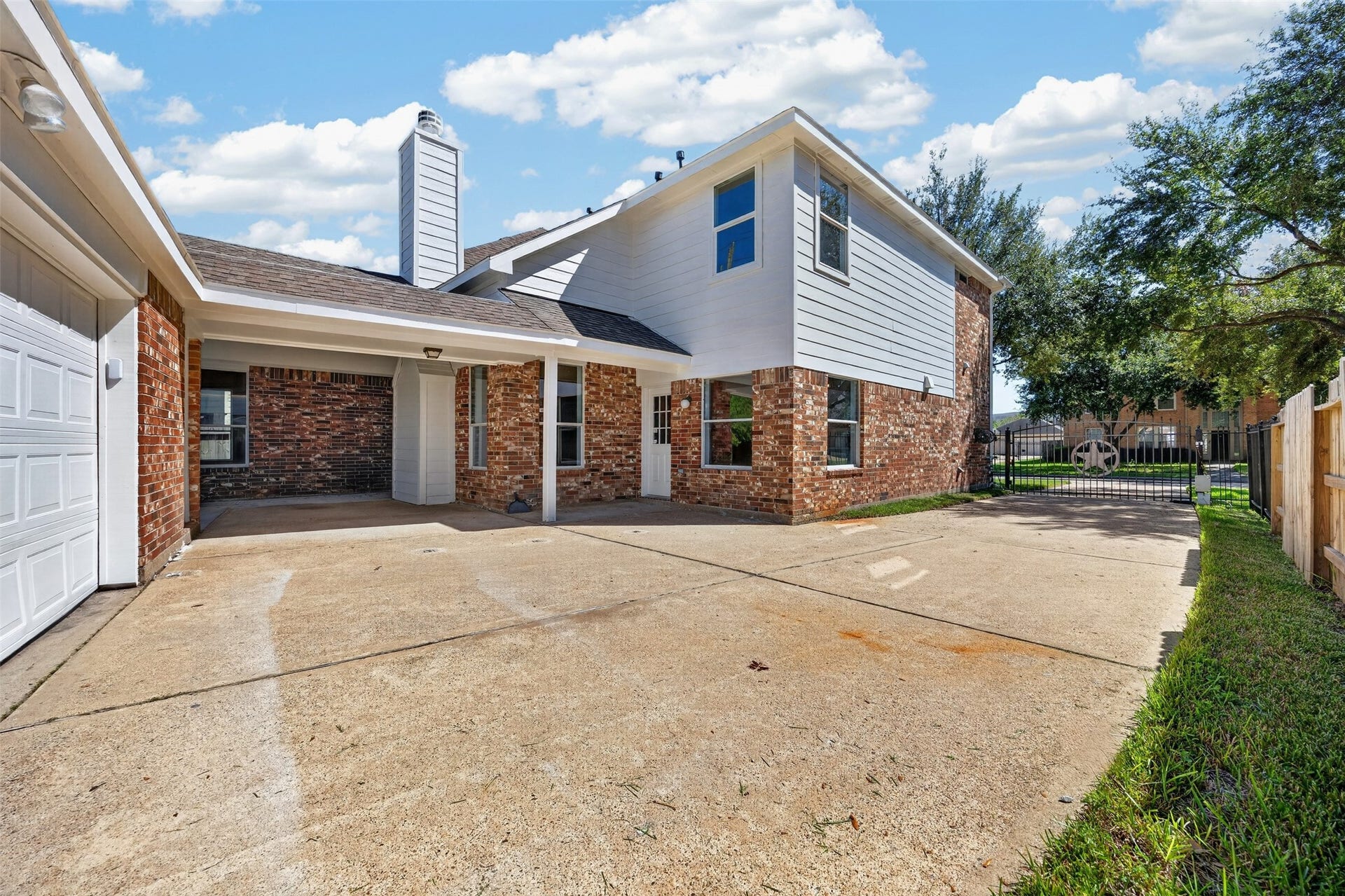 3114 Brannon Hill Lane, Sugar Land, TX 77479 Spacious driveway featuring an automatic gate and a two-car garage, offering outdoor space for parking and activities.
