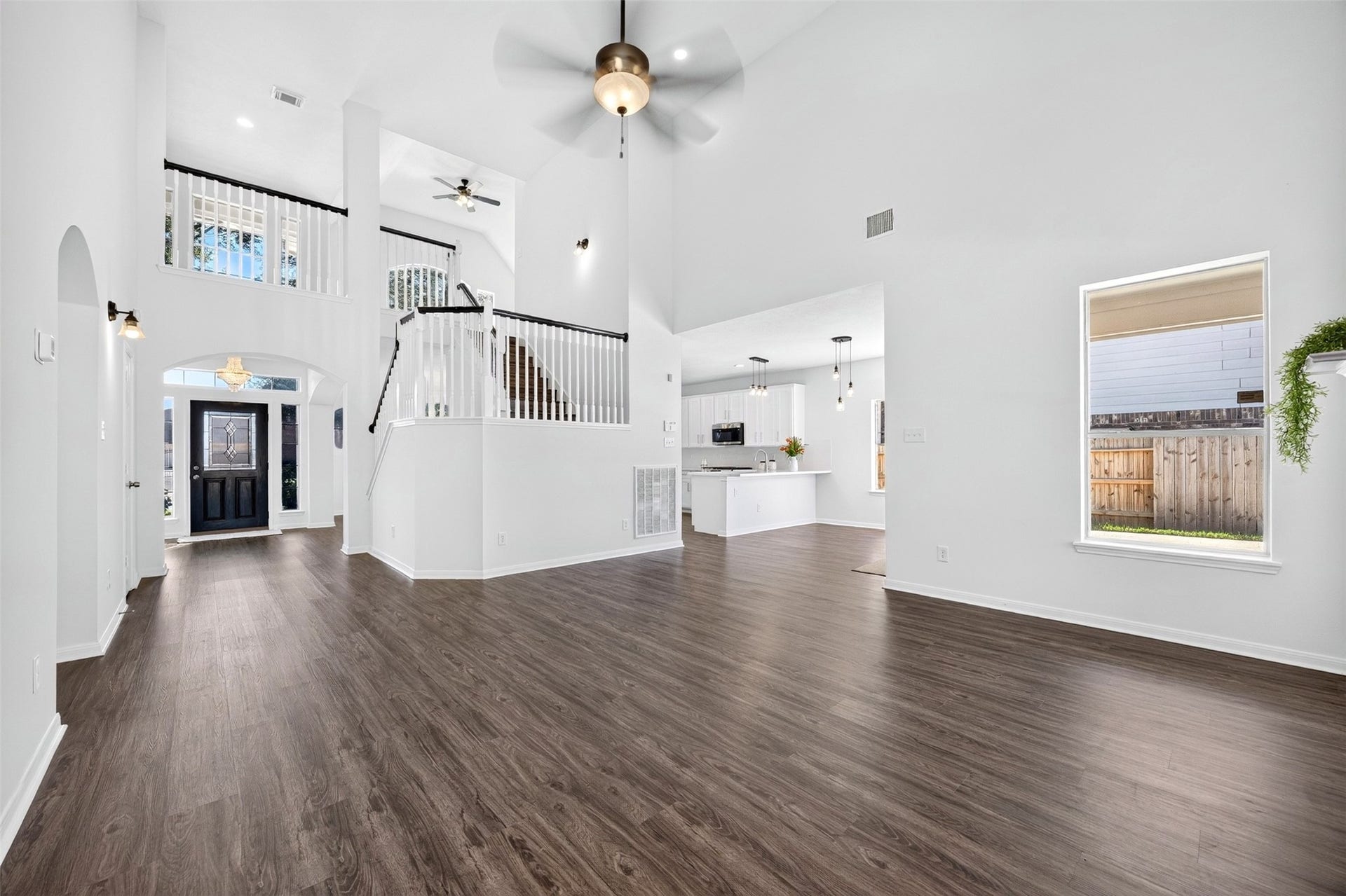3114 Brannon Hill Lane, Sugar Land, TX 77479 Spacious open-concept living area with high ceilings, elegant staircase, and abundant natural light, seamlessly leading to a modern kitchen and inviting entryway.
