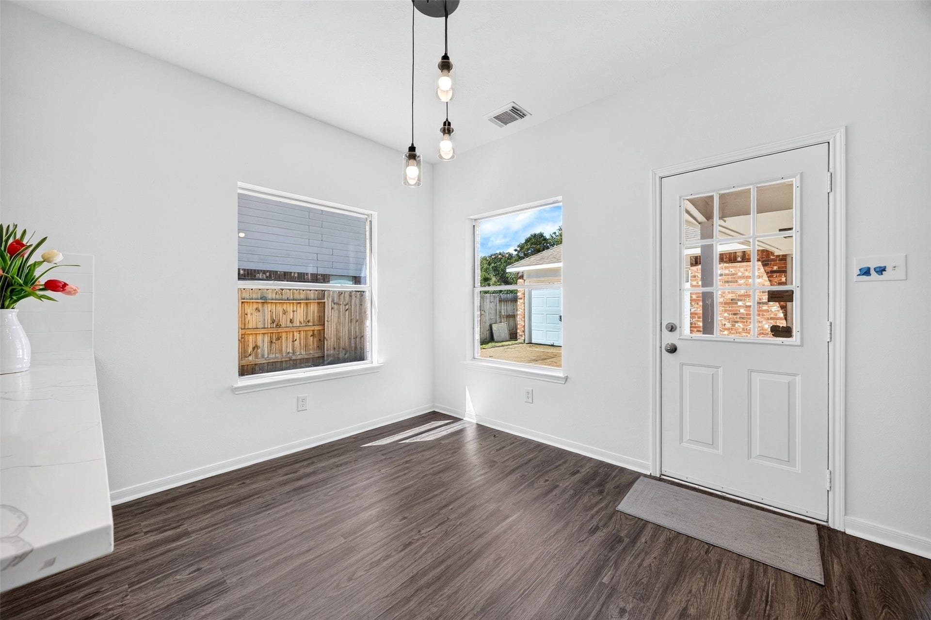 3114 Brannon Hill Lane, Sugar Land, TX 77479 Bright and inviting breakfast area large windows, modern lighting, leading to a charming outdoor space.
