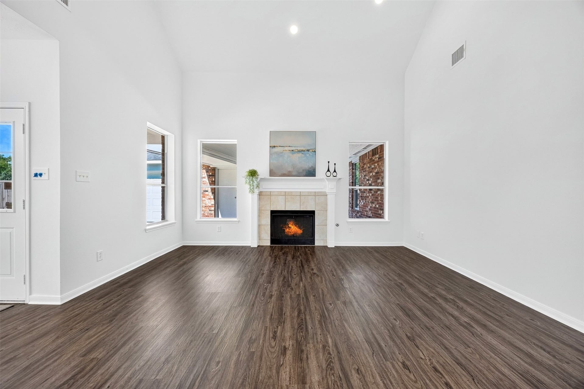 3114 Brannon Hill Lane, Sugar Land, TX 77479 Spacious living room with high ceilings, a cozy fireplace, and 3 windows that provide abundant natural light.