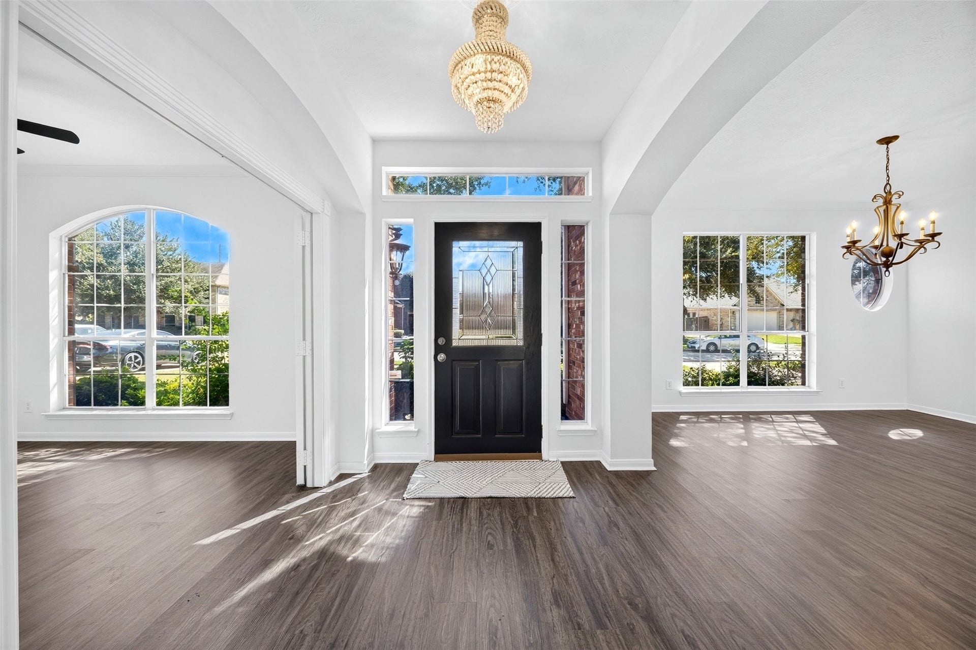 3114 Brannon Hill Lane, Sugar Land, TX 77479 Bright and inviting entryway with luxury vinyl plank flooring, large windows for natural light, and a stylish chandelier accentuating the space.
