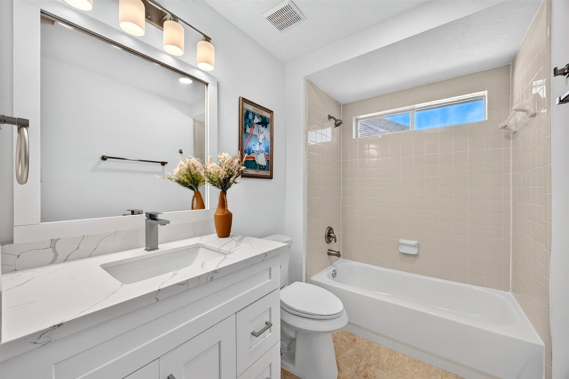 3114 Brannon Hill Lane, Sugar Land, TX 77479 Bright and modern bathroom featuring a sleek vanity with a marble countertop, elegant lighting, and a cozy bathtub beneath a high window for natural light.