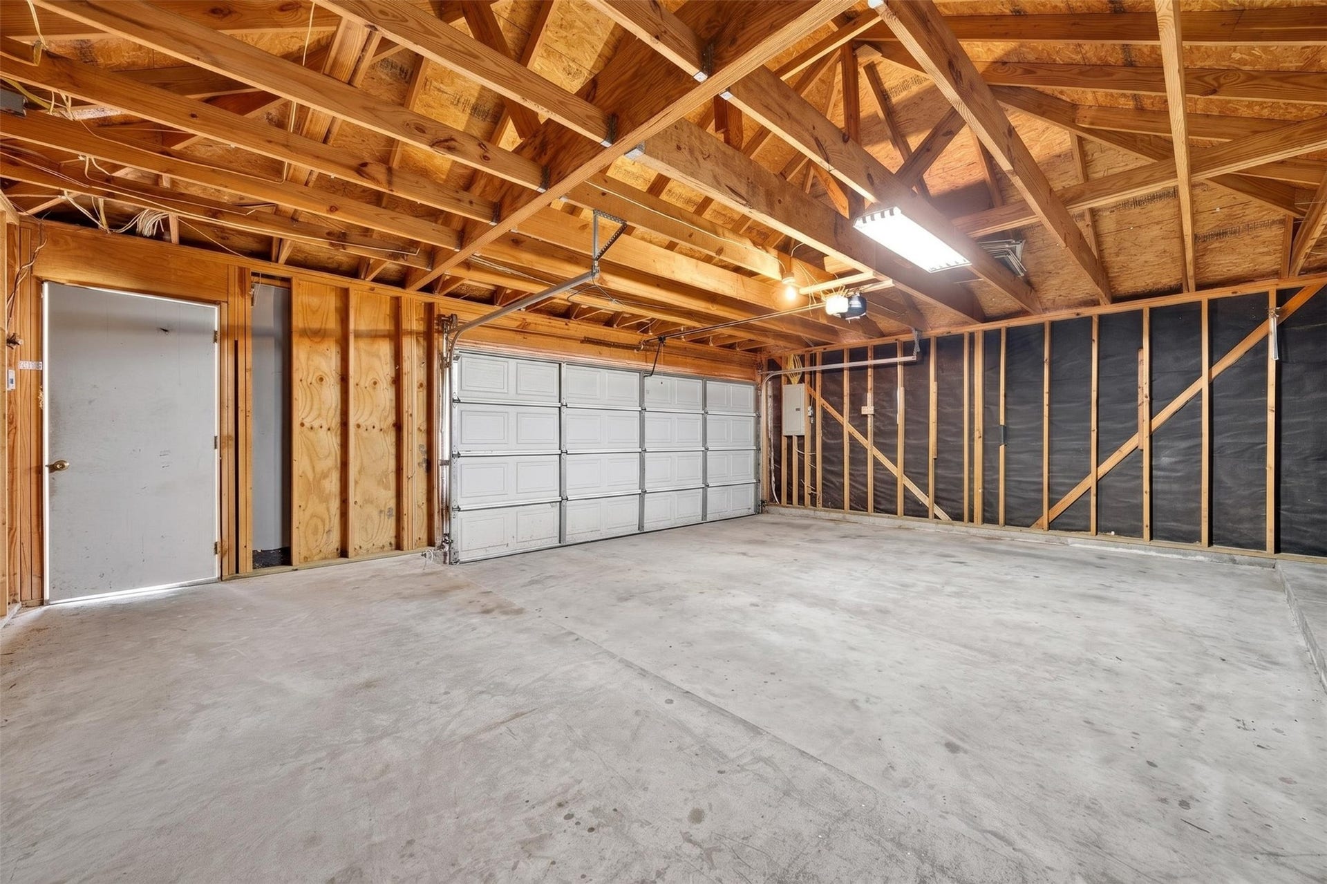 3114 Brannon Hill Lane, Sugar Land, TX 77479 Spacious two-car garage with exposed beams and ample lighting, perfect for storage or a workshop.