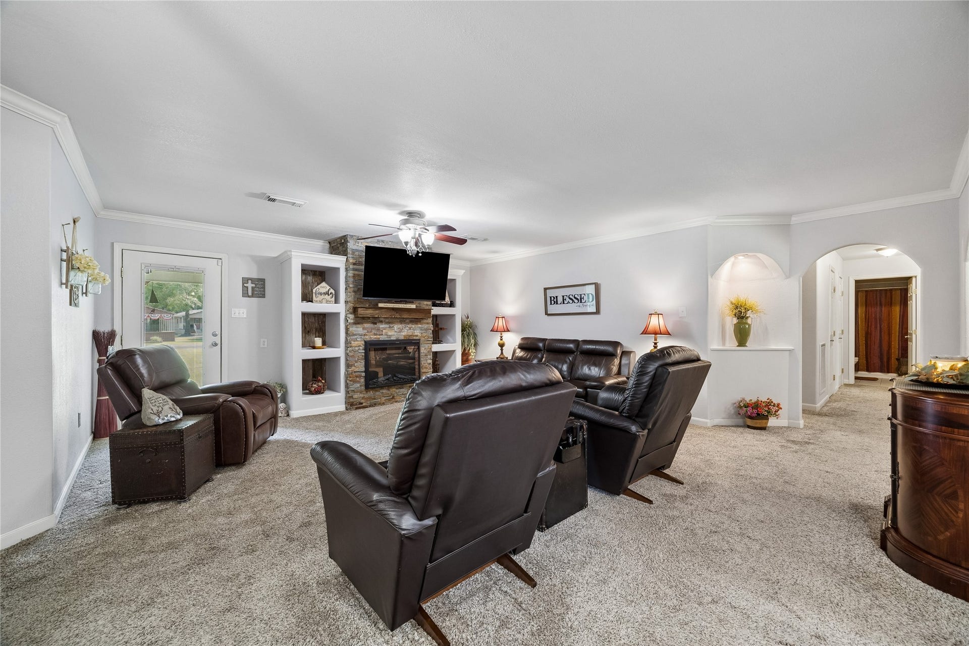 26904 Brentwood Road, Splendora, TX 77372 Living room featuring a fireplace, a lit recessed art niche, and access to the back door
