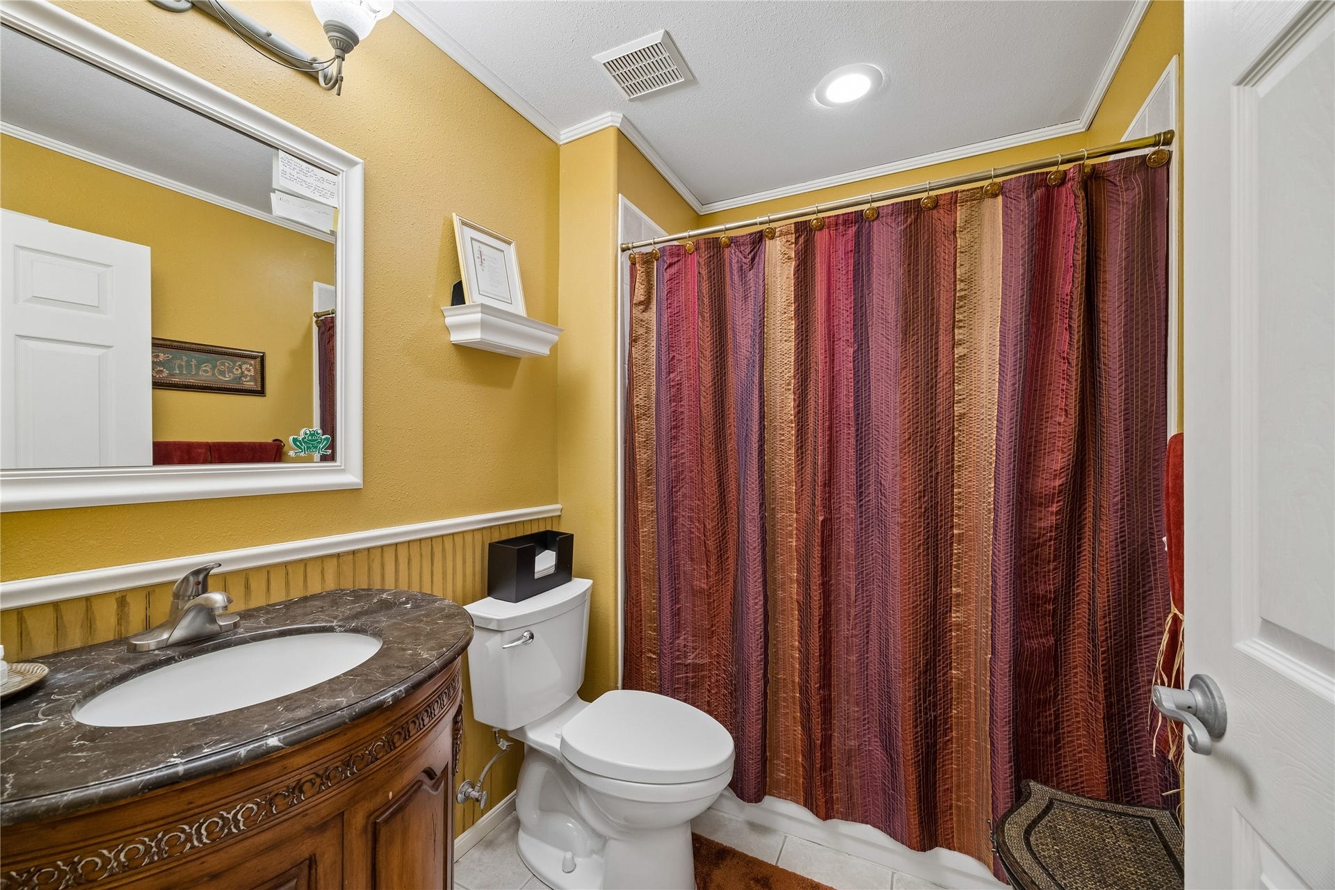 26904 Brentwood Road, Splendora, TX 77372 Full bath featuring an elegant rounded wooden vanity and a traditional shower-tub combo.