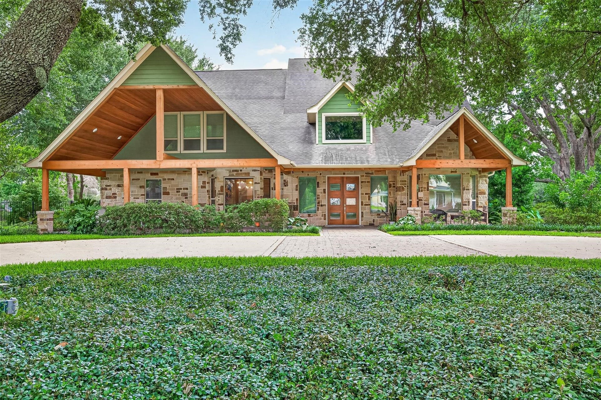 Shaded by mature live oak trees and lush landscaping throughout