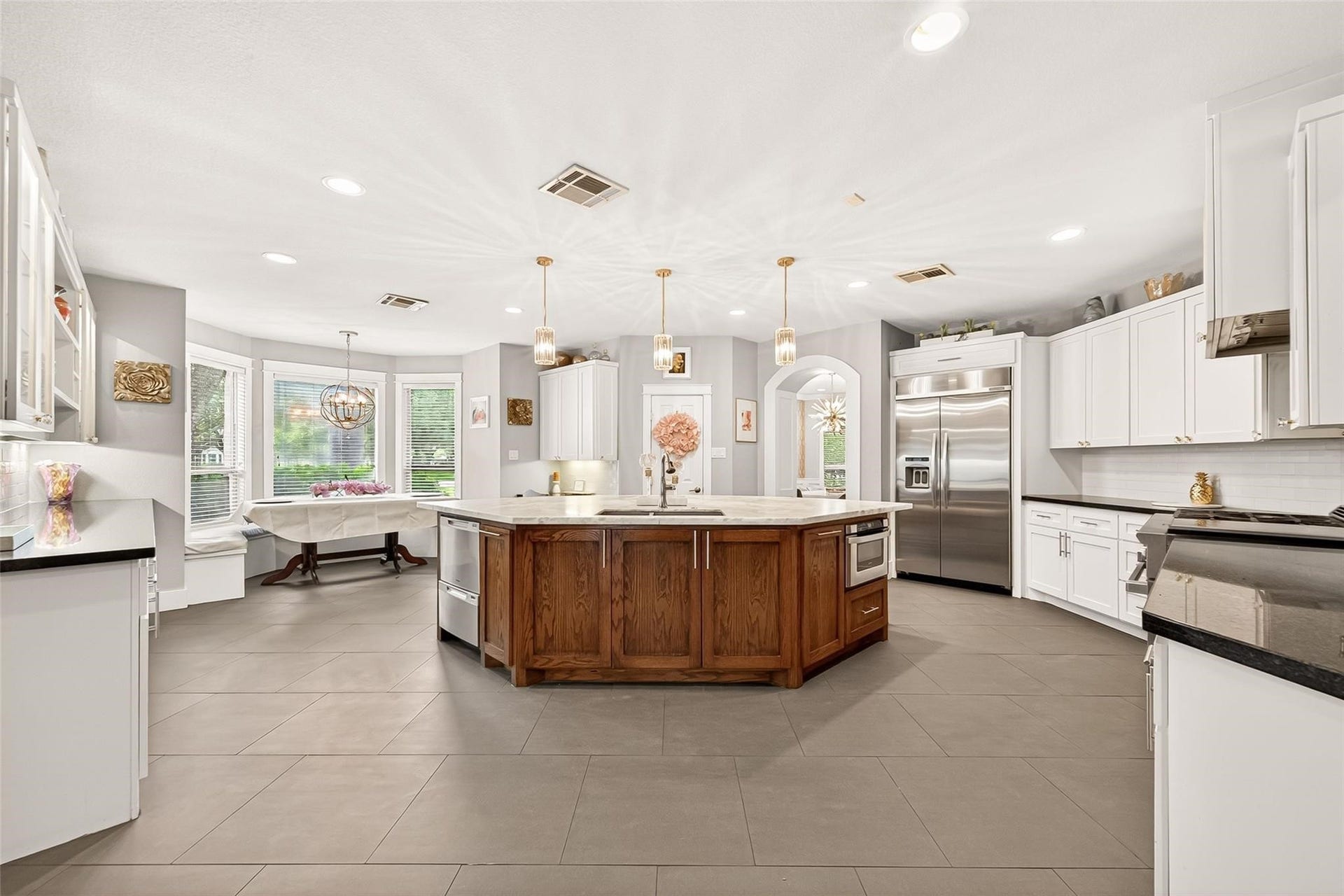 Welcome to your dreamy chef's kitchen! Stainless steel appliances, luxurious honed marble island, ambient storage.