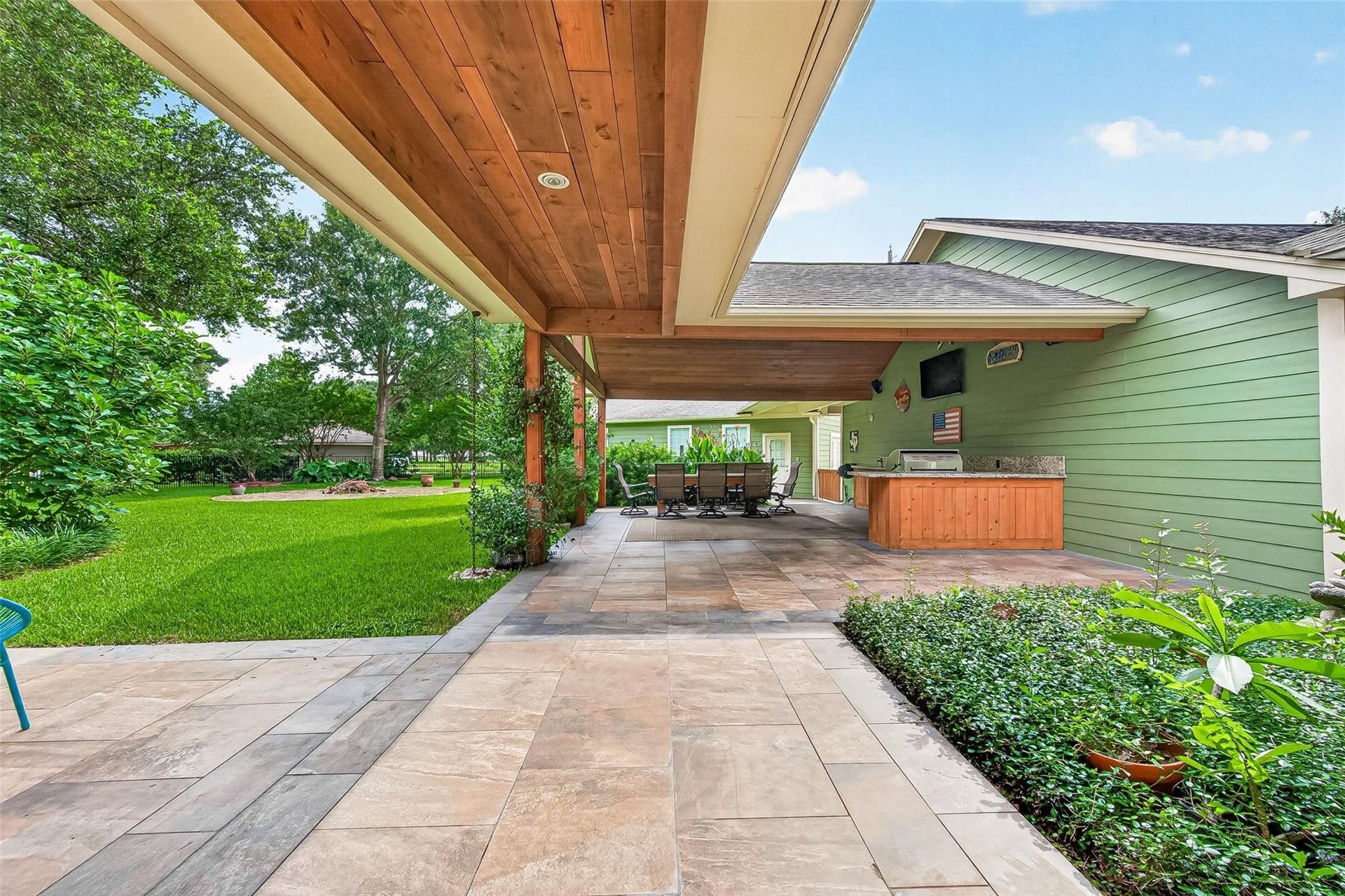 Covered outdoor kitchen with a gas grill, fridge and icemaker