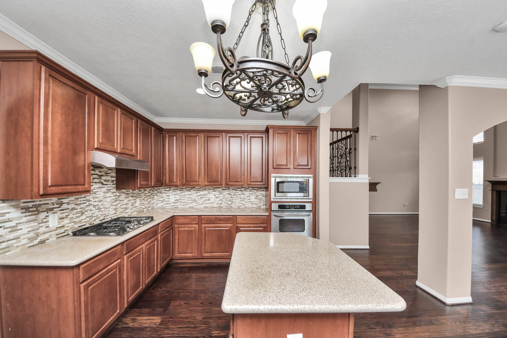 Elegant kitchen featuring rich wood cabinetry, modern stainless steel appliances, and a stylish tile backsplash.