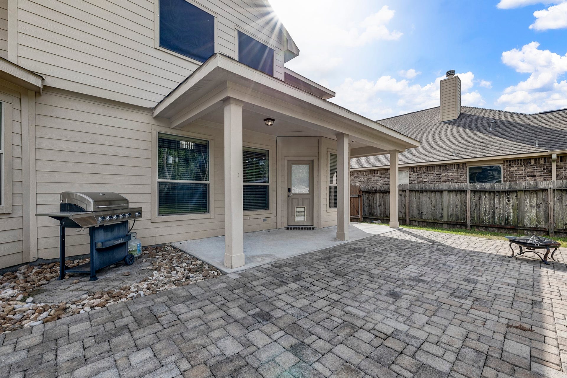 33227 Greenfield Forest Drive, Magnolia, TX 77354 Spacious backyard patio with a covered area, perfect for outdoor grilling and entertaining, featuring a built-in BBQ and ample space for gatherings.