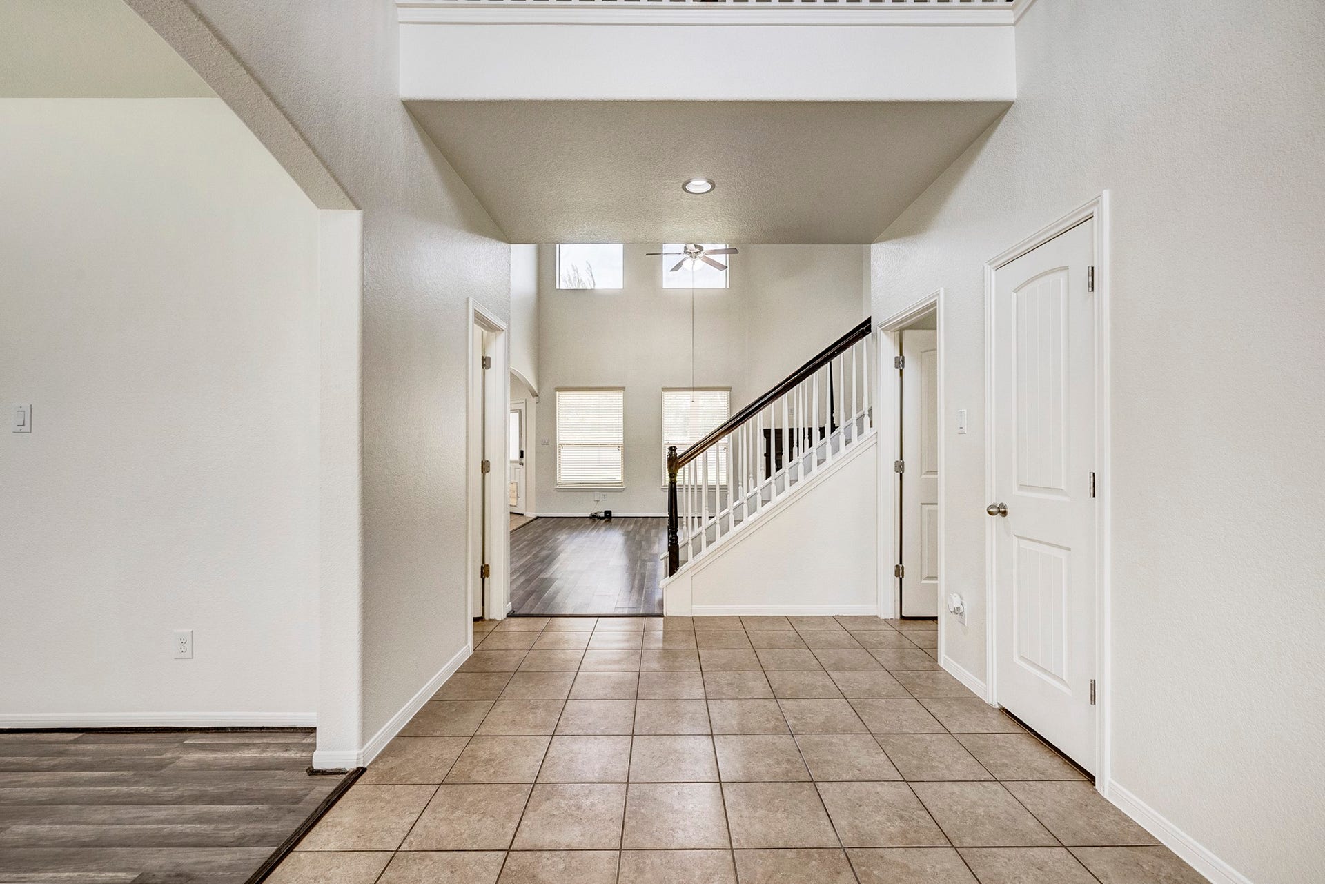 33227 Greenfield Forest Drive, Magnolia, TX 77354 Spacious entryway featuring sleek tile flooring, high ceilings, and a modern staircase leading to the second floor.