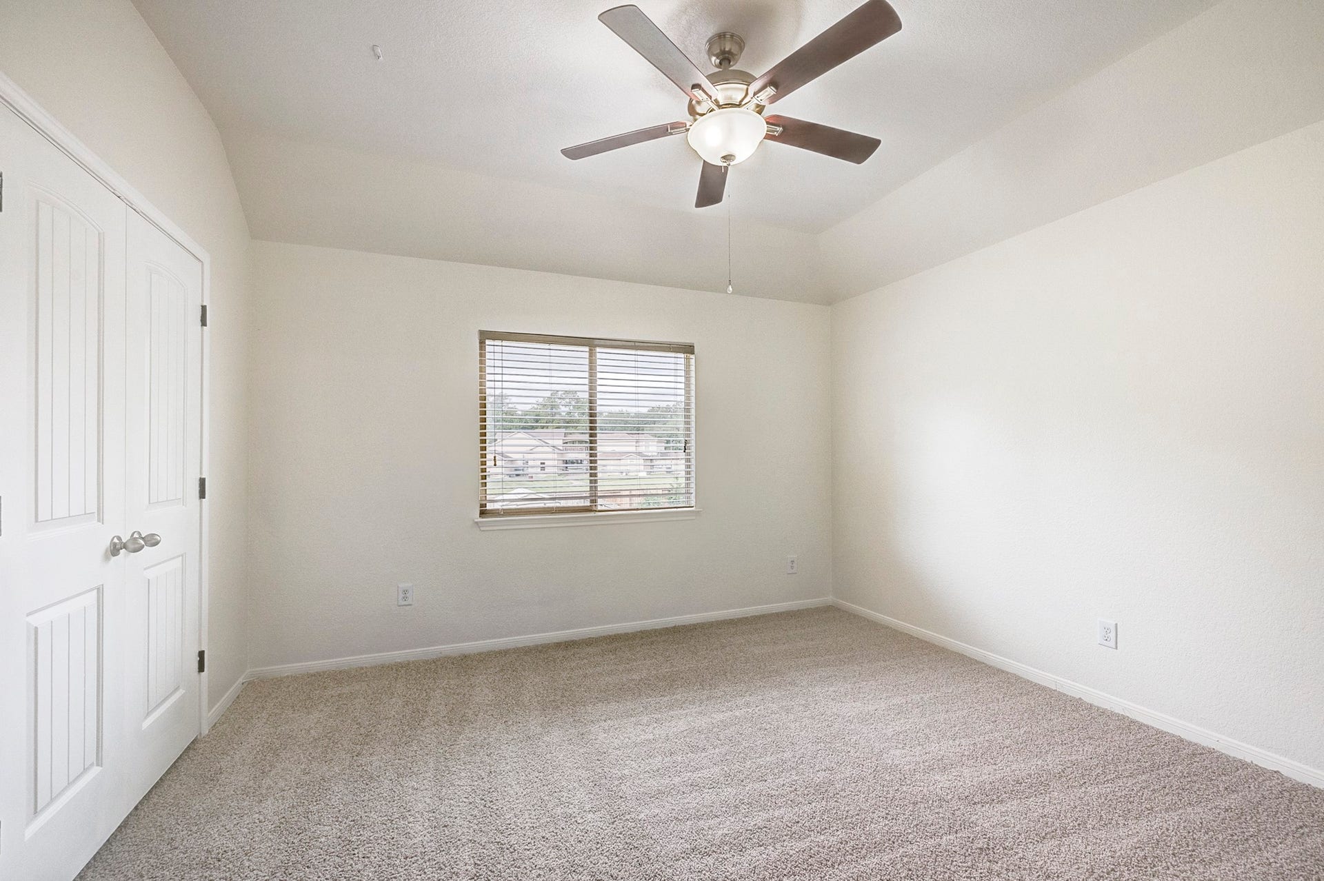 33227 Greenfield Forest Drive, Magnolia, TX 77354 Spacious bedroom with plush carpeting, a ceiling fan, and ample natural light from the window.