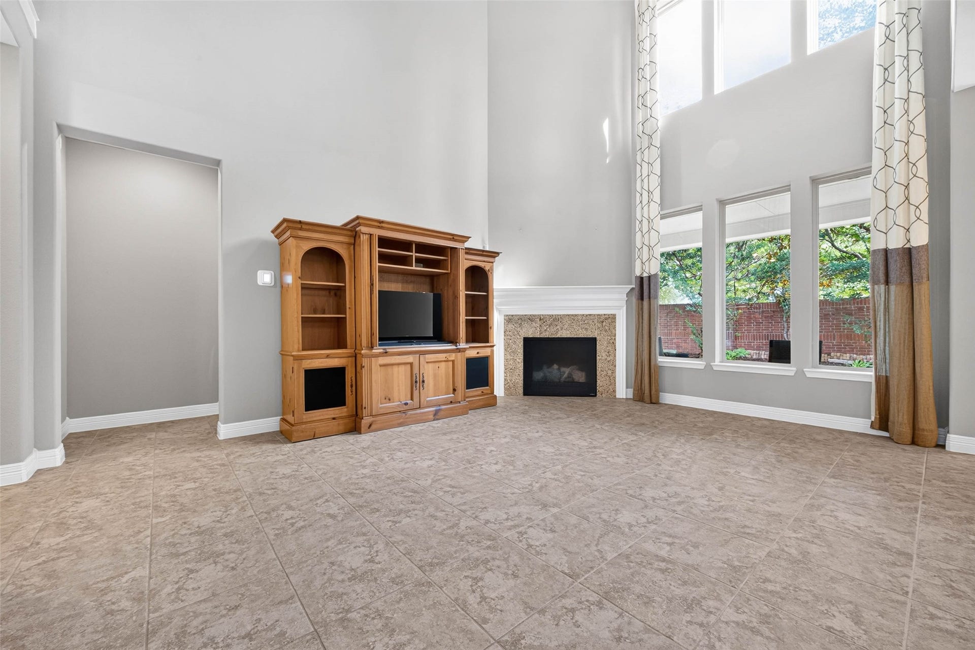 4419 Montcliff Bend Court, Sugar Land, TX 77479 Living room featuring a cozy fireplace and large windows that provide abundant natural light