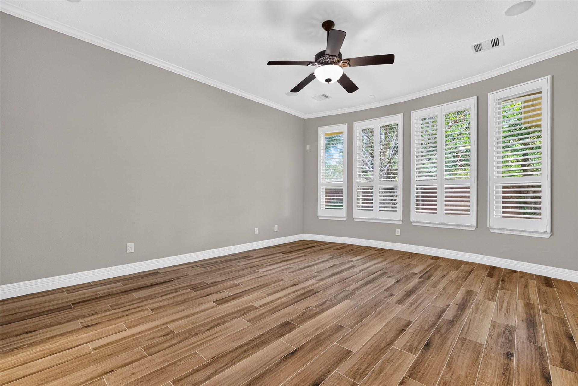 4419 Montcliff Bend Court, Sugar Land, TX 77479 Primary bedroom featuring four large windows, a ceiling fan, and ample space for furniture
