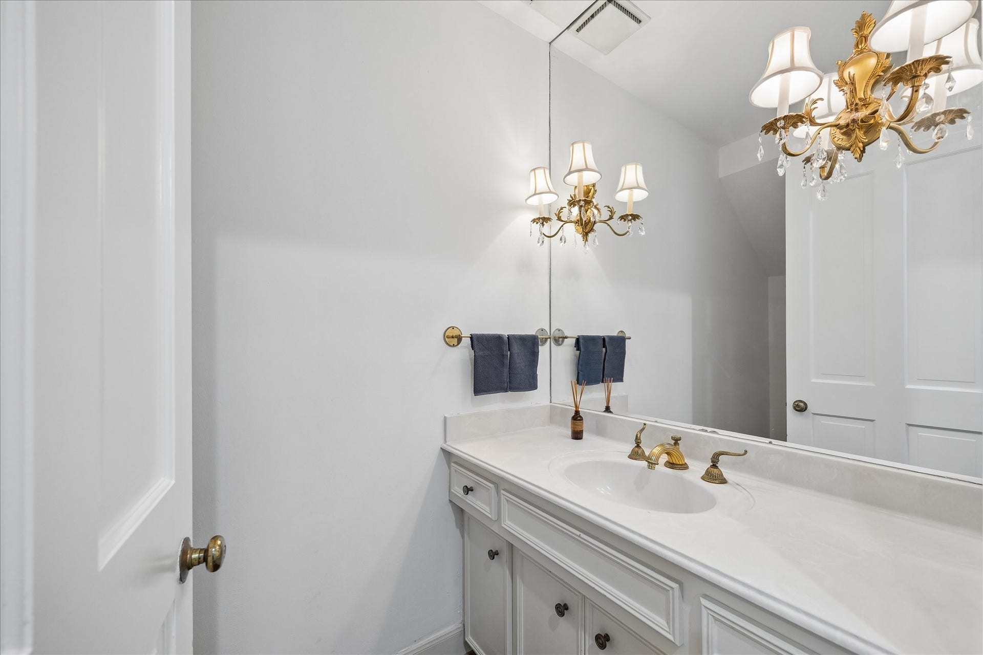 1422 Nantucket Drive, #C, Houston, TX 77057 First-floor powder bath with generous counter space, large mirror and decorative brass sconces.