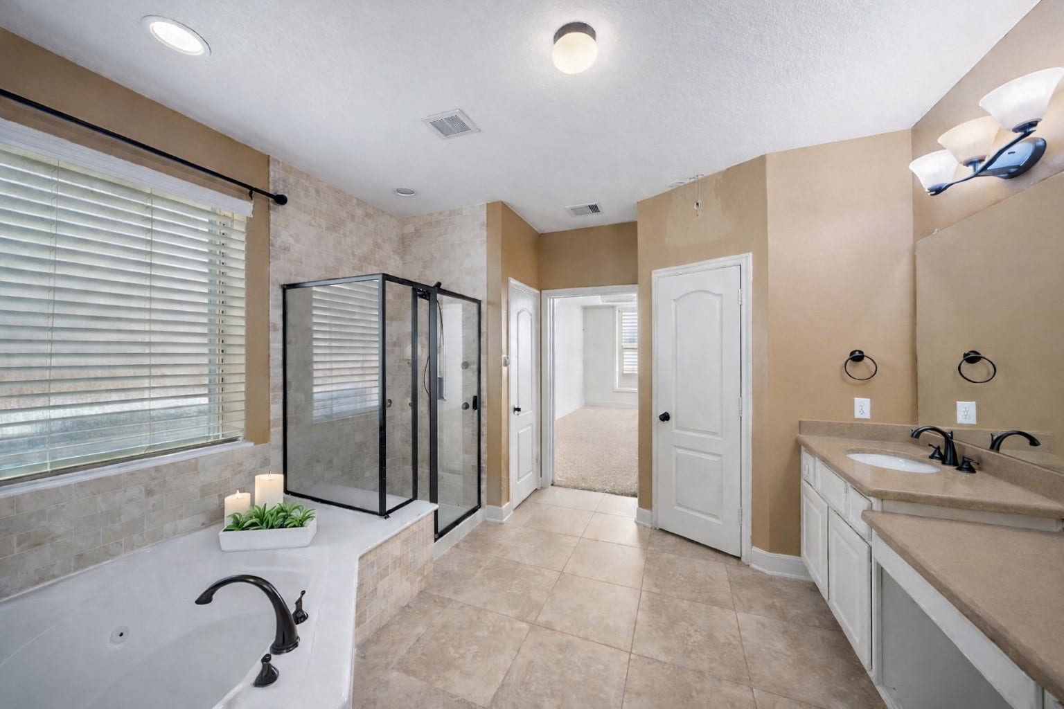 14318 Red Creek Cove Lane, Humble, TX 77396 Primary bathroom features a modern glass shower, a large bathtub with stylish fixtures, dual sinks with ample counter space, and neutral tile and wall colors, creating a serene and inviting atmosphere.