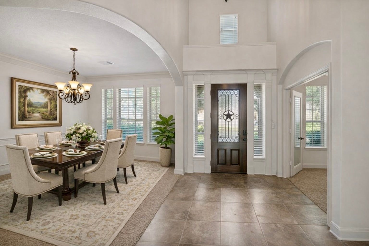 14318 Red Creek Cove Lane, Humble, TX 77396 This elegant entryway features a spacious foyer with a tiled floor, leading into a bright dining room with a large window. A solid wood front door with glass panels adds a touch of sophistication.