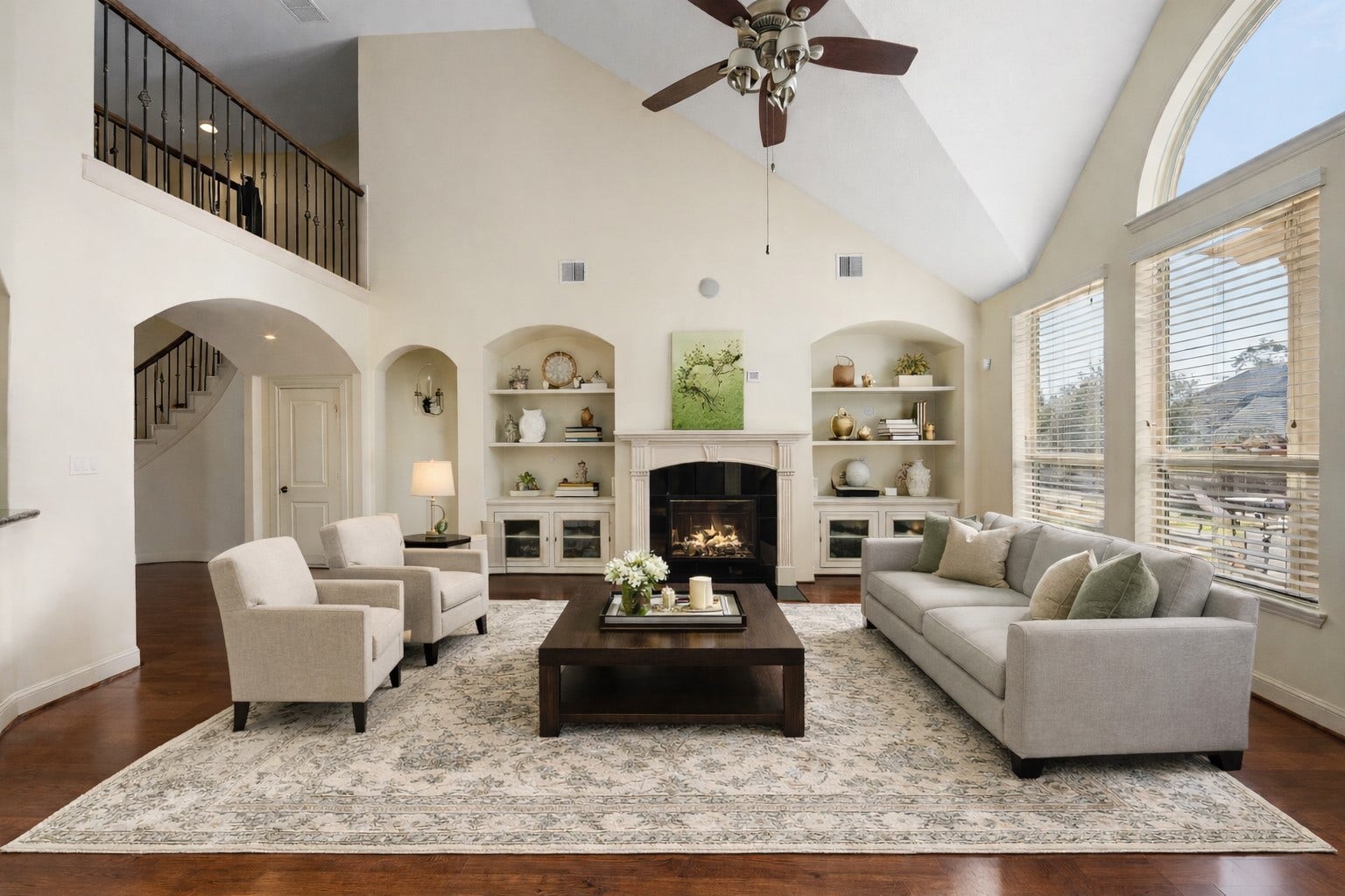 14318 Red Creek Cove Lane, Humble, TX 77396 Inviting living room features high ceilings, a cozy fireplace, and large arched windows overlooking the pool - offering plenty of natural light.