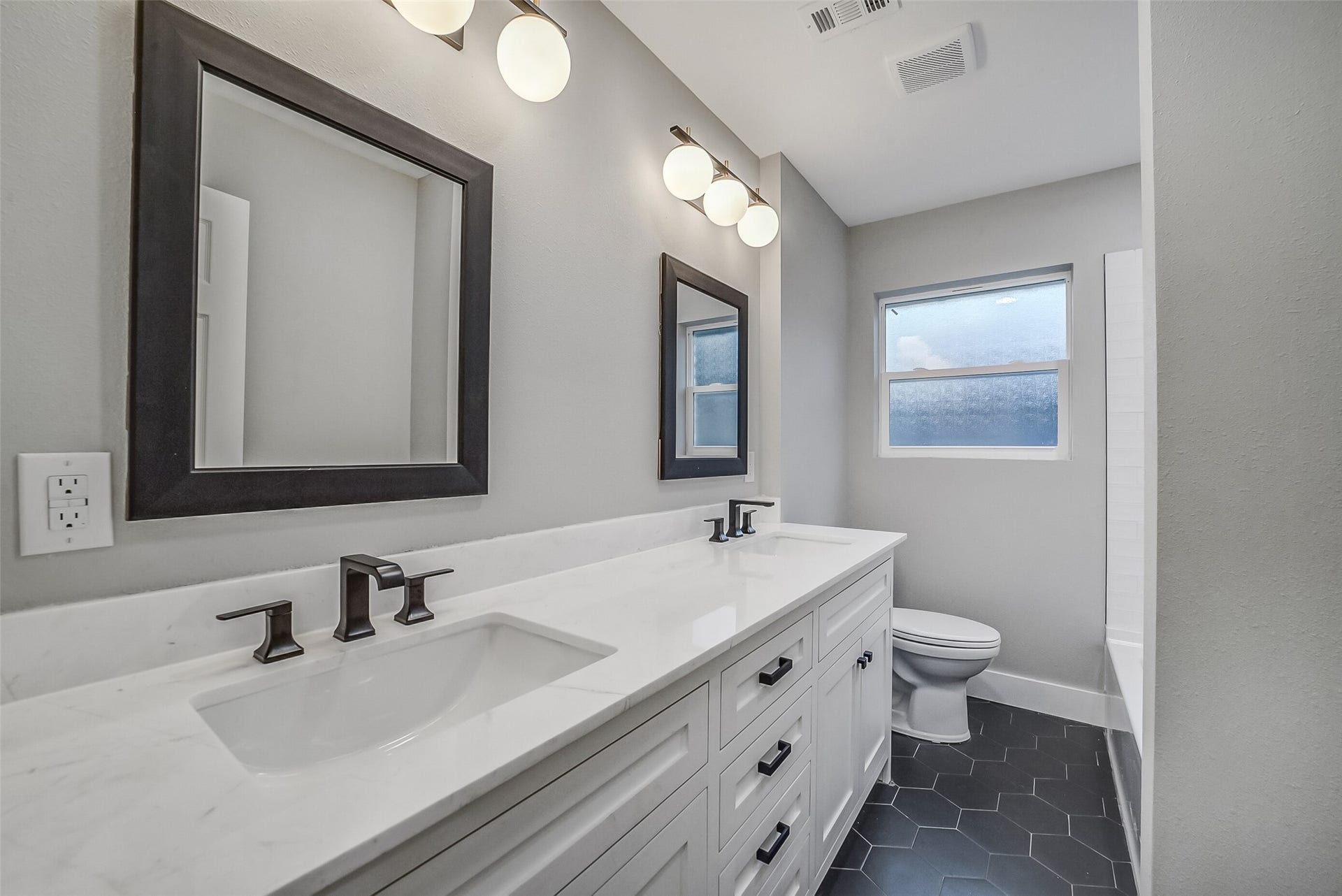 5318 Queensloch Drive, Houston, TX 77096 Great secondary bathroom with ample counter space, modern tile floor and shower/tub combo.