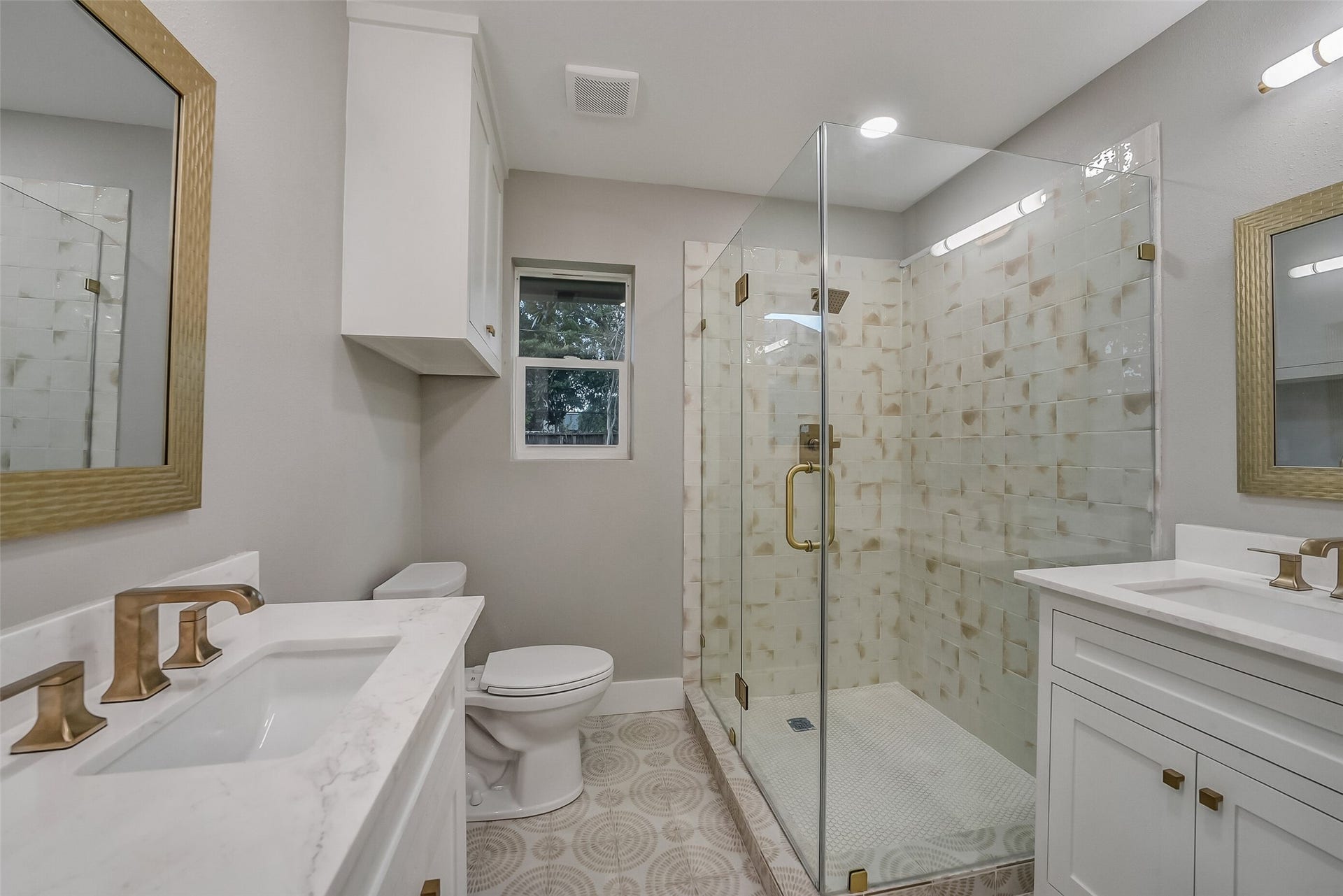 5318 Queensloch Drive, Houston, TX 77096 Beautifully updated master bathroom with separate vanity sinks and glass enclosed walk-in shower.