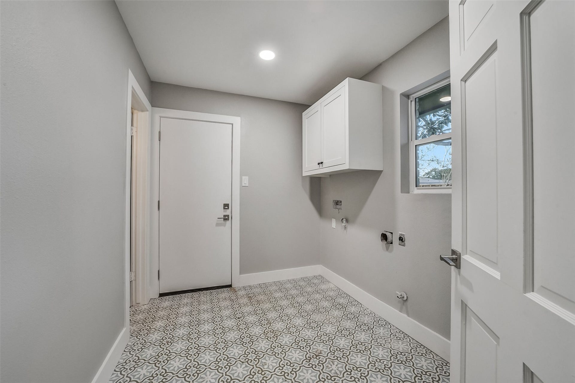 5318 Queensloch Drive, Houston, TX 77096 Laundry room with patterned tiled floor and plenty of room for storage.