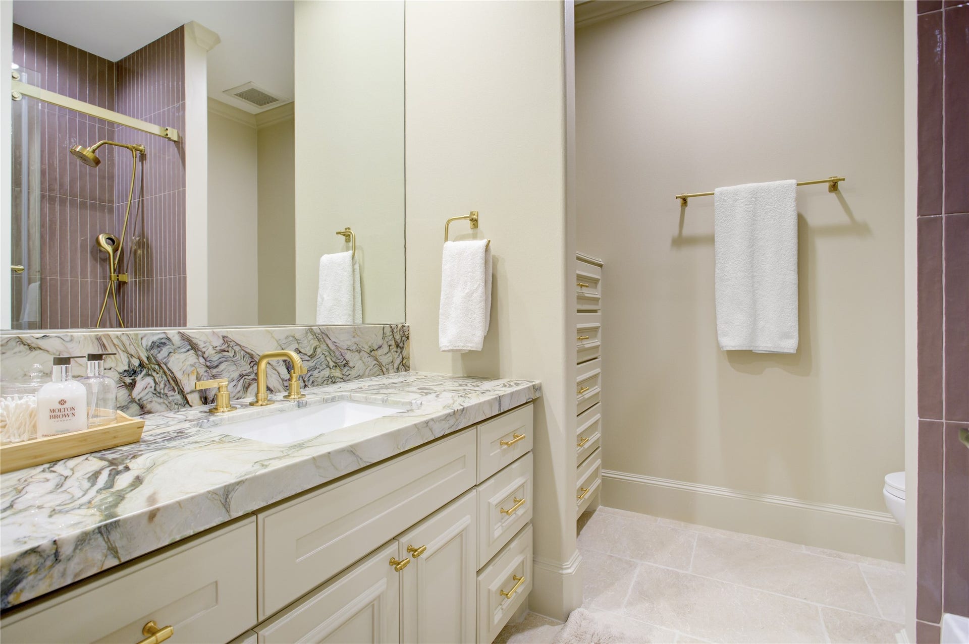 2215 North Boulevard, Houston, TX 77098 Mauve linear tile, green fusion countertops, and travertine flooring create a distinctive, artfully layered ensuite.