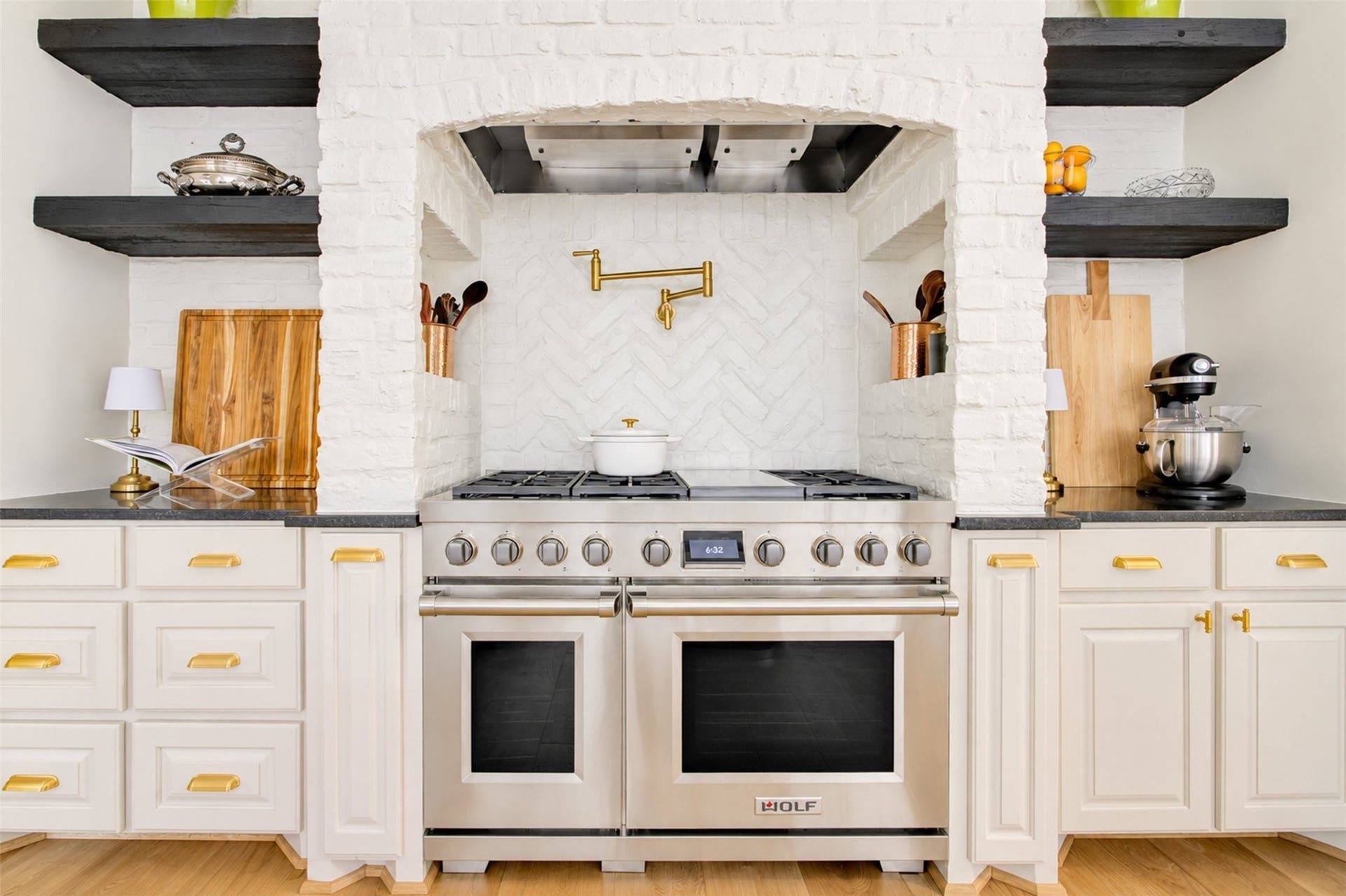 2215 North Boulevard, Houston, TX 77098 A Wolf professional range with double ovens ancors the herringbone brick cooking alcove, complete with a Kohler brass pot filler.