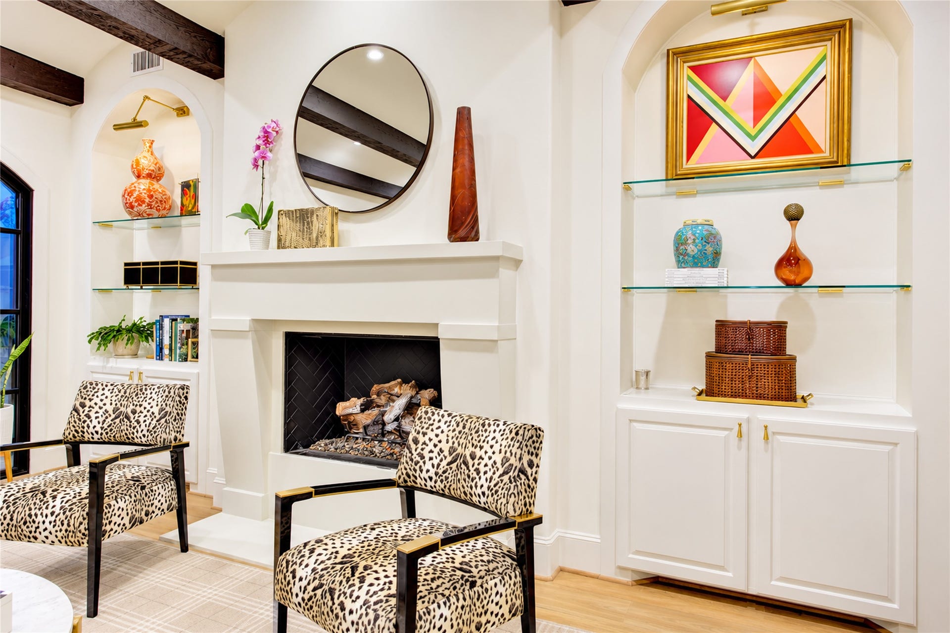 2215 North Boulevard, Houston, TX 77098 A cast stone gas-log fireplace with a classic mantel anchors the living room, flanked by arched display niches with floating glass shelves.