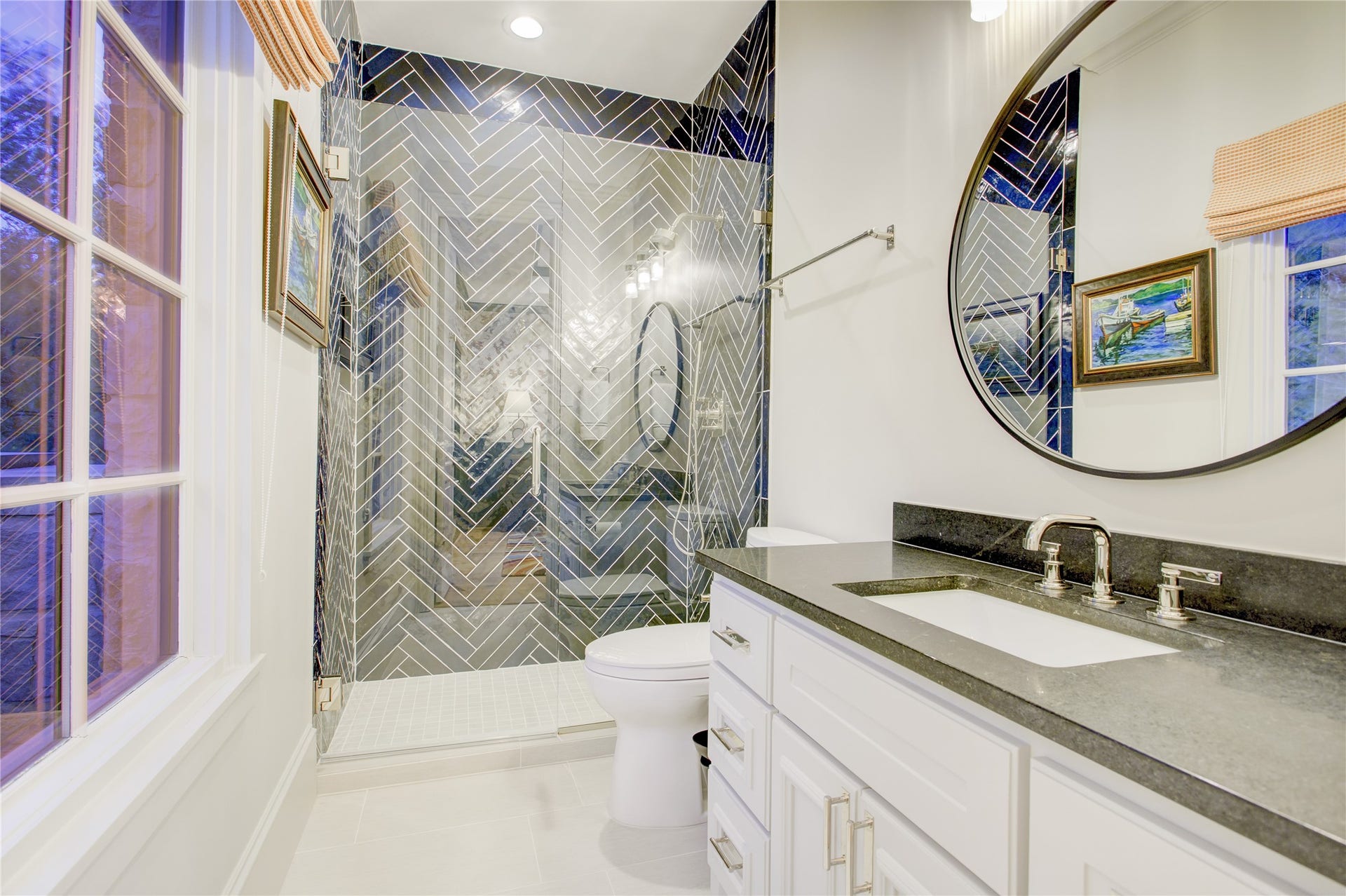 2215 North Boulevard, Houston, TX 77098 Floor-to-ceiling navy herringbone tile, a frameless glass shower, and honed black granite define this sophisticated ensuite.